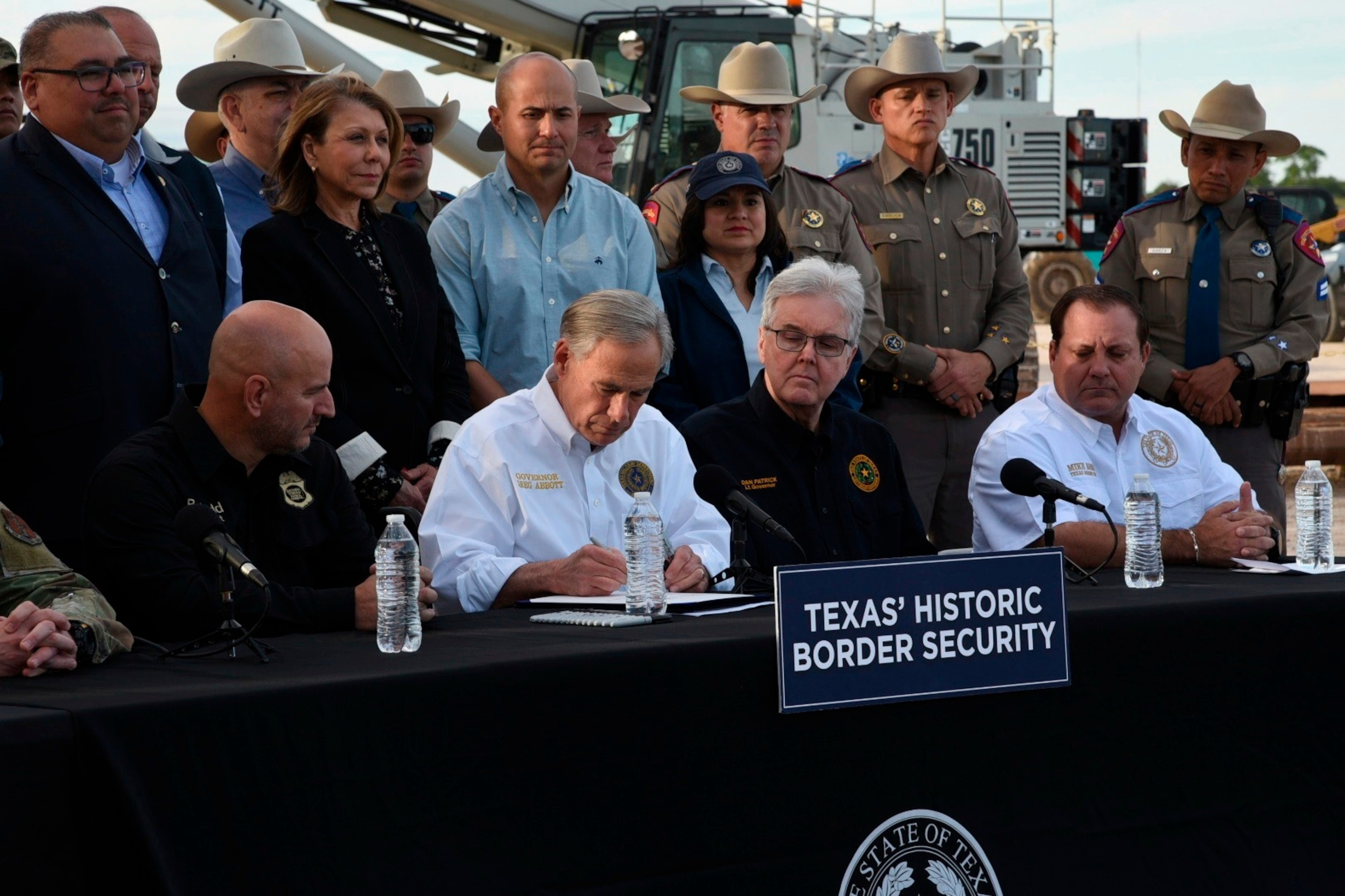 PHOTO: Gov. Greg Abbott signs three bills into law at a border wall construction site in Brownsville, Texas on Dec. 18, 2023.