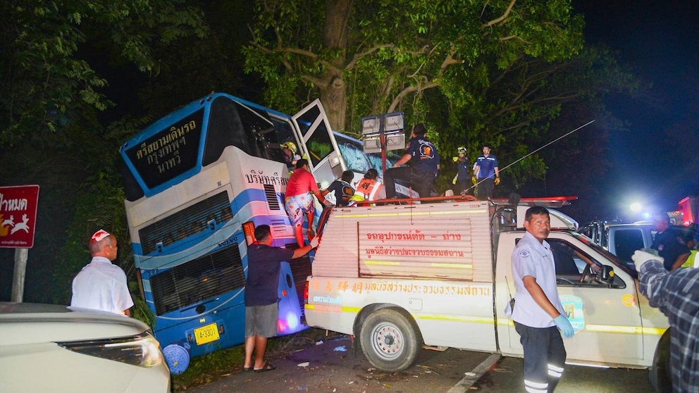 In this photo provided by Sawang Rungrueang Rescue22 Foundation, rescue workers and volunteers work at the site of a bus accident Tuesday, Dec 5, 2023, at the Prachuap Khiri Khan province, Thailand. A dozen of people were killed after the vehicle fell off the road and hit a big tree.(Sawang Rungrueang Rescue22 Foundation via AP)