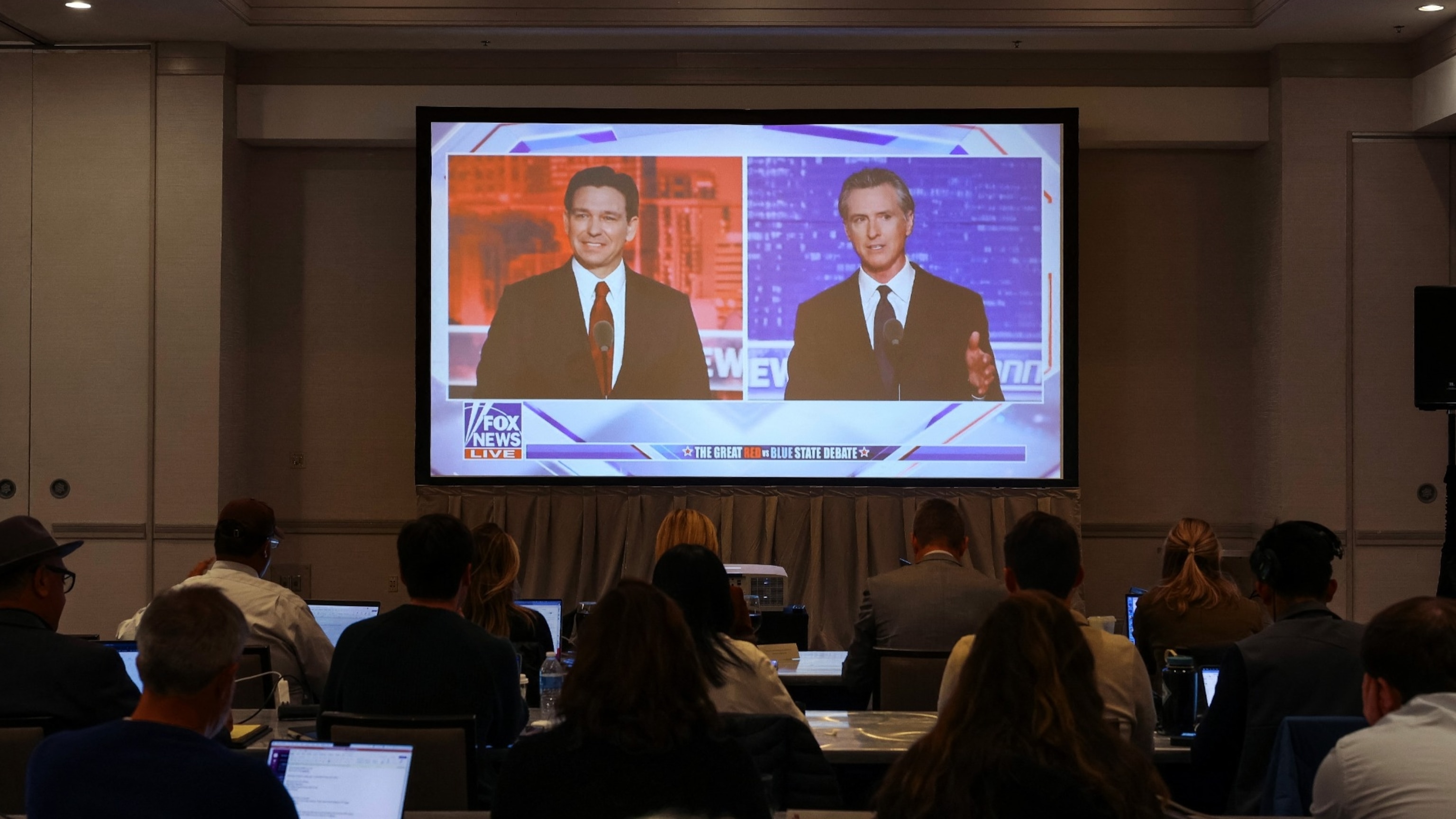 PHOTO: Journalists watch Florida Governor and Republican presidential candidate Ron DeSantis debate California Governor Gavin Newsom on a screen in the media room, in Alpharetta, Georgia, Nov. 30, 2023. 