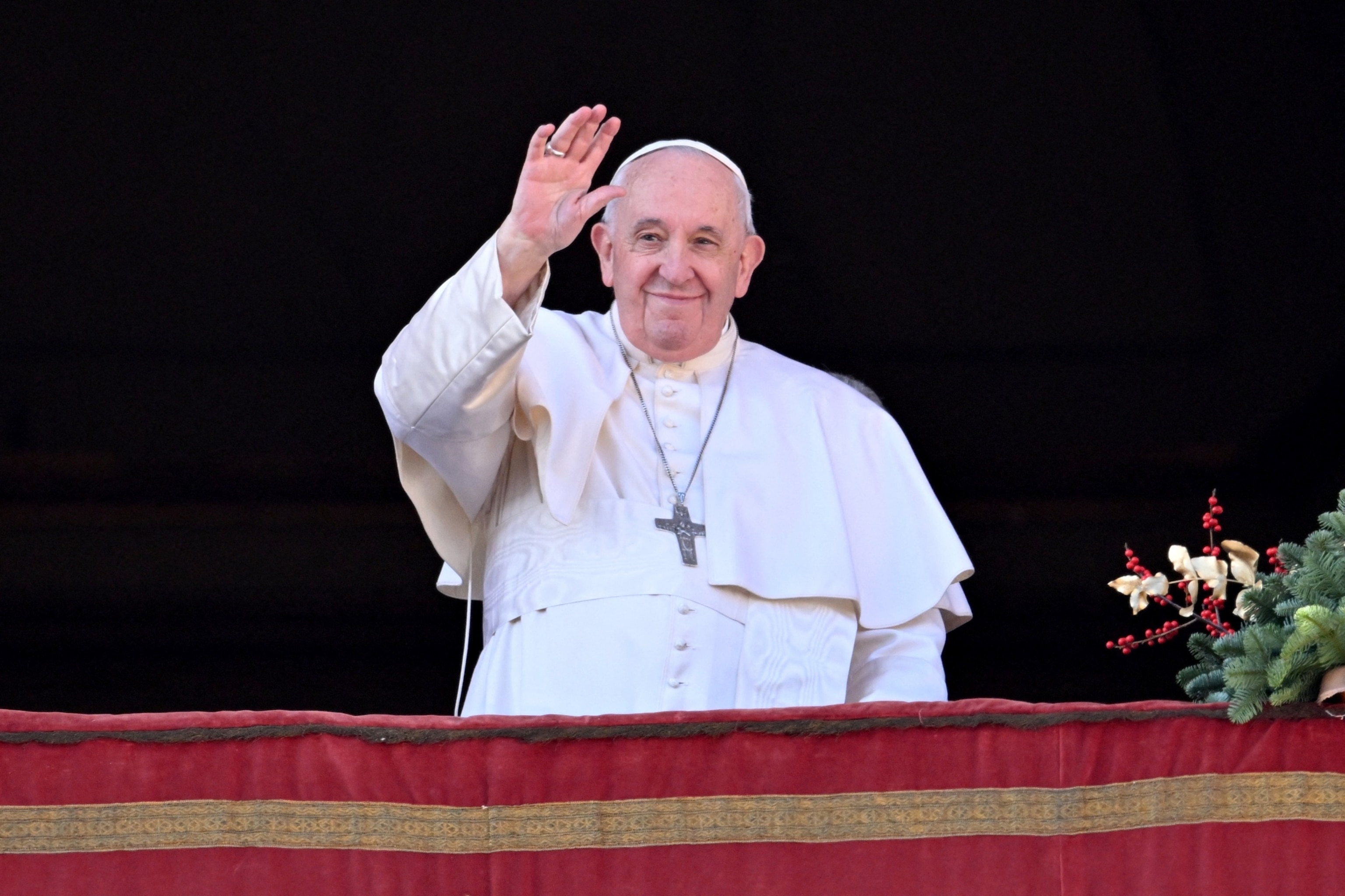 PHOTO: Pope Francis waves to the crowd as he appears at the balcony to deliver his Christmas Urbi et Orbi blessing in St. Peter's Square at The Vatican on December 25, 2022.