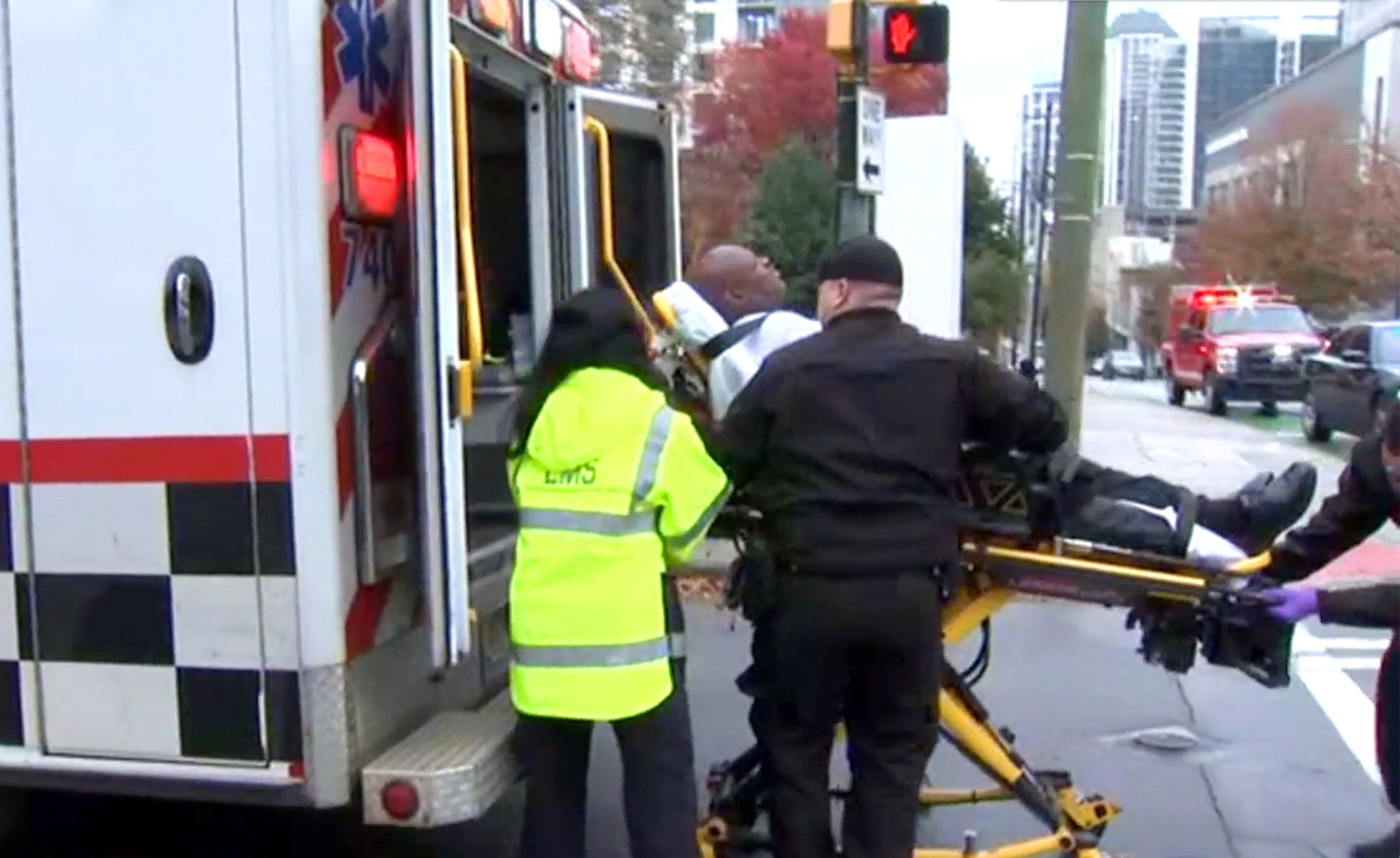 PHOTO: A security guard is placed in an ambulance after being injured when a protester set themselves on fire in an apparent "political protest" outside an Israeli Consulate office in Atlanta, Dec. 1, 2023.