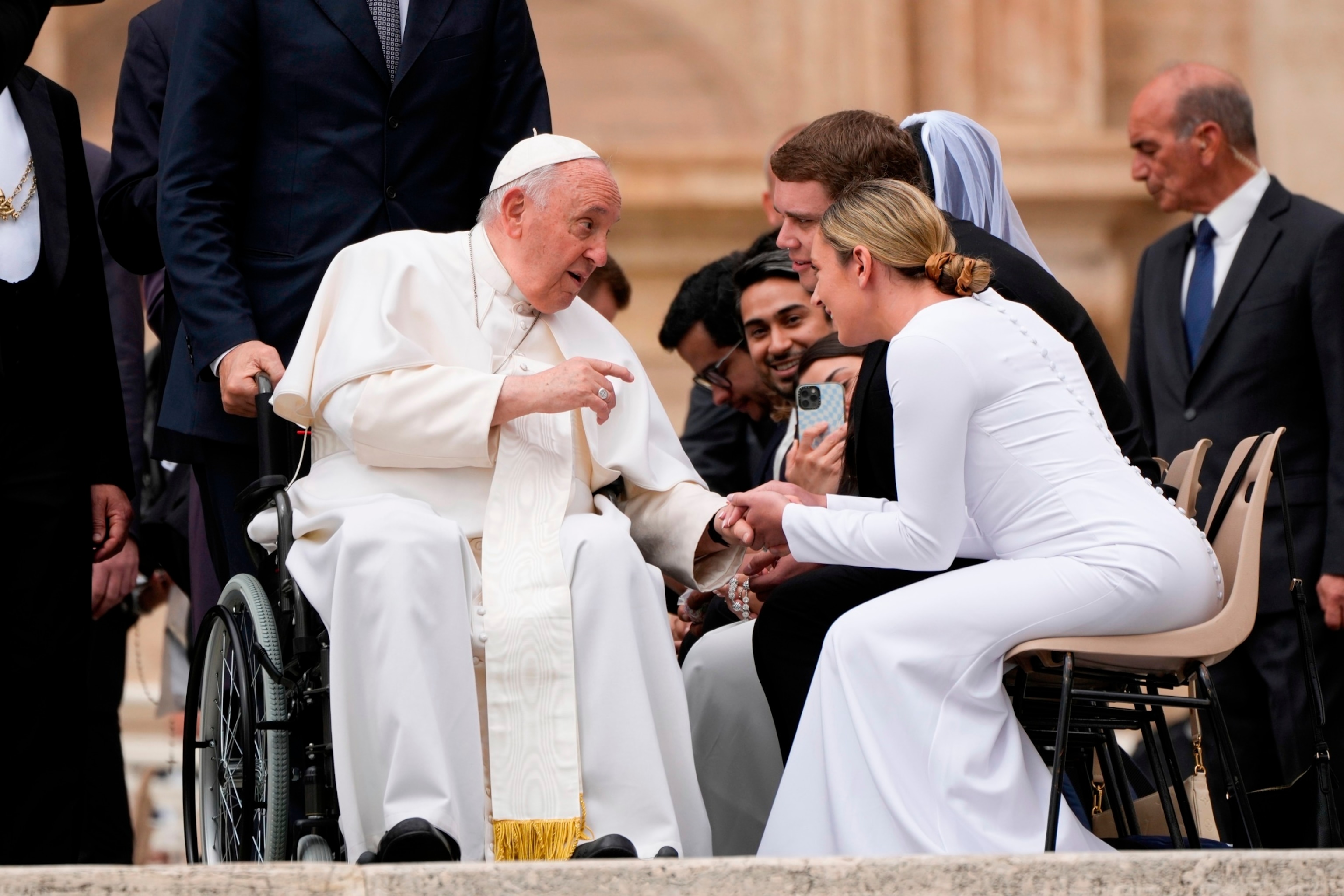 PHOTO: Pope Francis is greeted by a young married couple at the end of his weekly general audience in St. Peter's Square at The Vatican, May 3, 2023. 