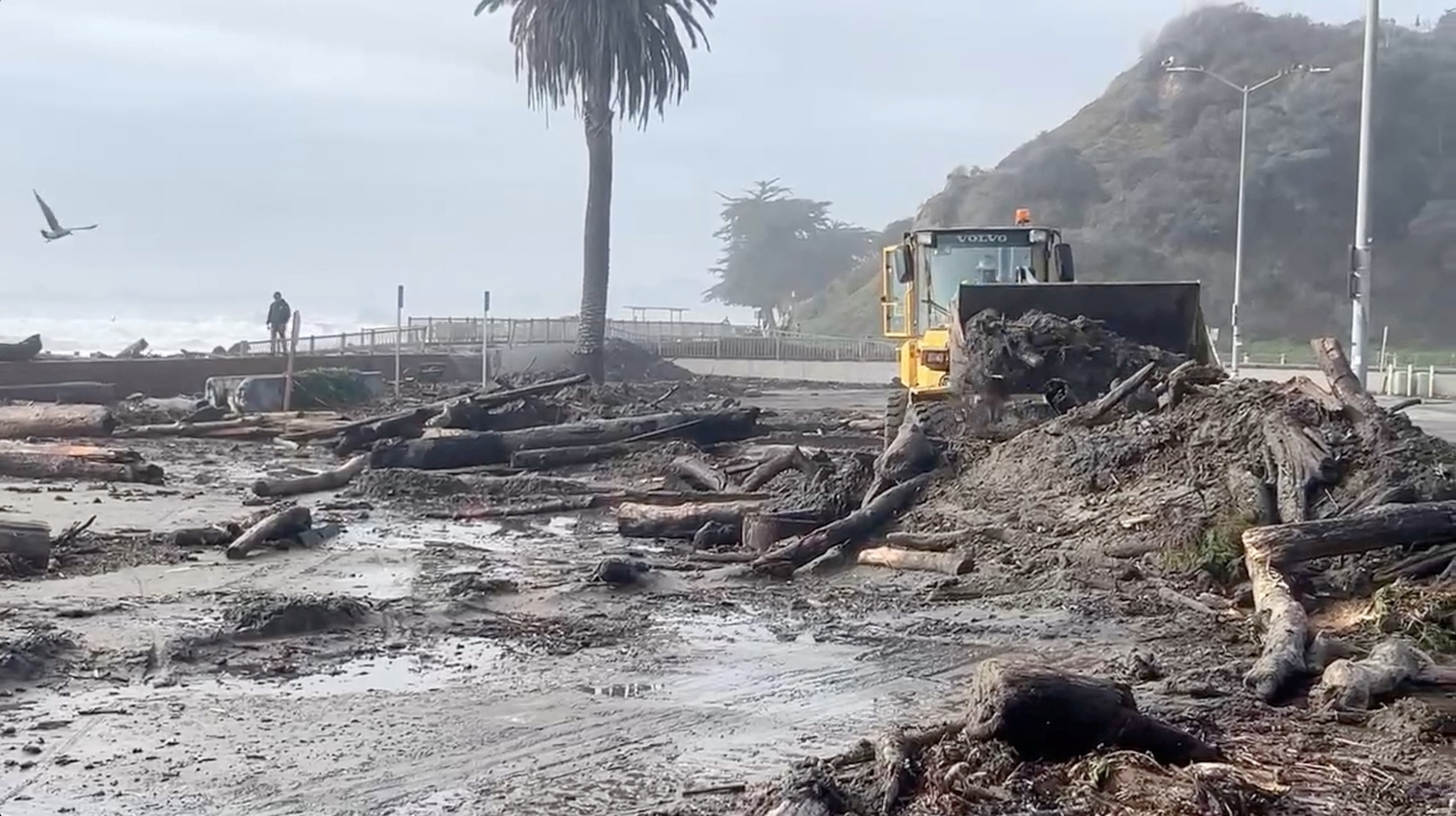 PHOTO: A heavy machinery clears mud and fallen trees off the beach, as massive waves hit the California coastline, in Santa Cruz county, U.S., Dec. 28, 2023, in this screengrab obtained from a handout video. 