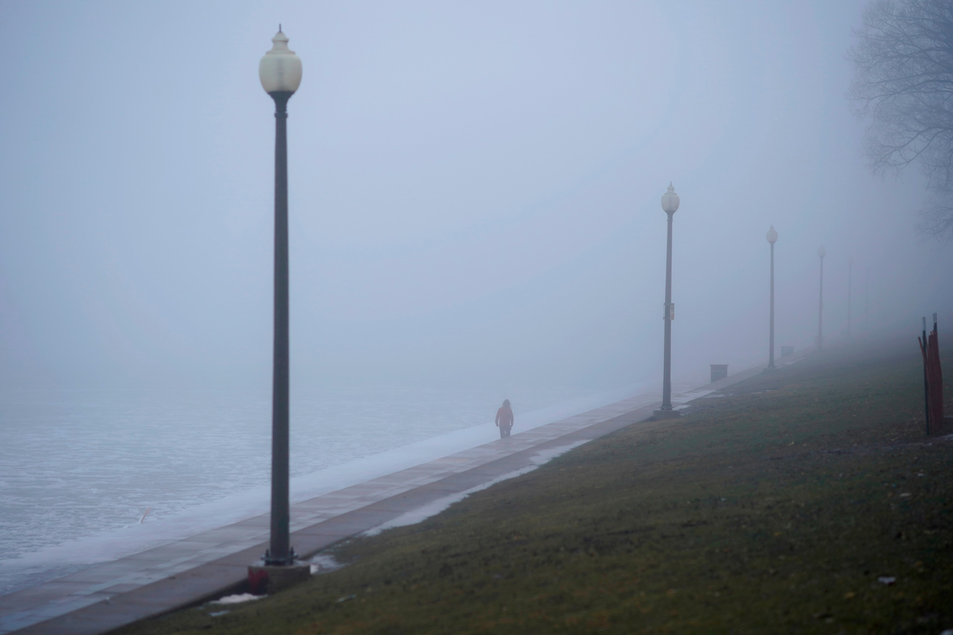 PHOTO: A lone man walks in dense fog along Lake Michigan near Chicago's Shedd Aquarium, Jan. 25, 2024, in Chicago. 