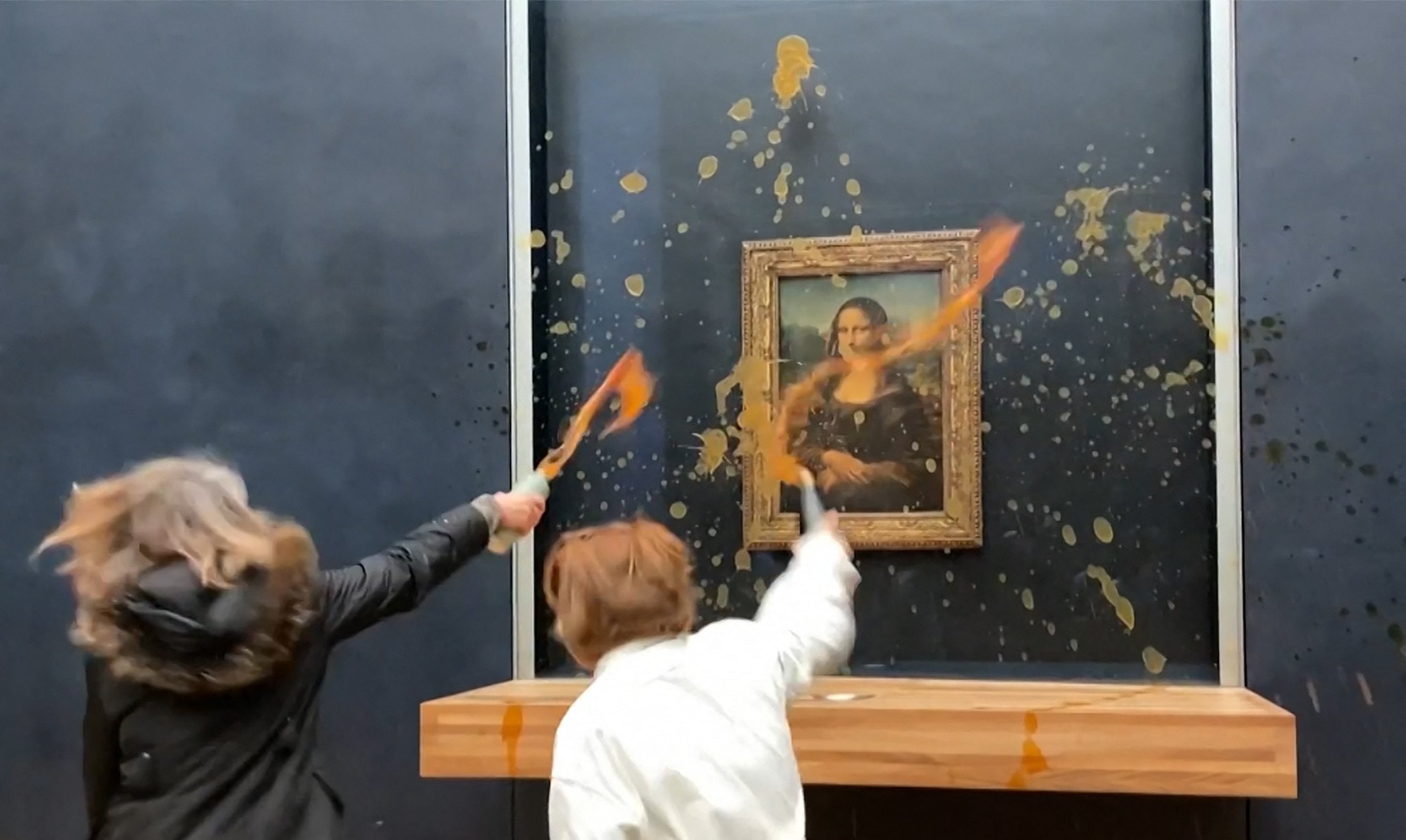 PHOTO: This image grab taken from AFPTV footage shows two environmental activists from the collective dubbed "Riposte Alimentaire" hurling soup at Leonardo Da Vinci's "Mona Lisa" (La Joconde) painting, at the Louvre museum in Paris, on Jan. 28, 2024.