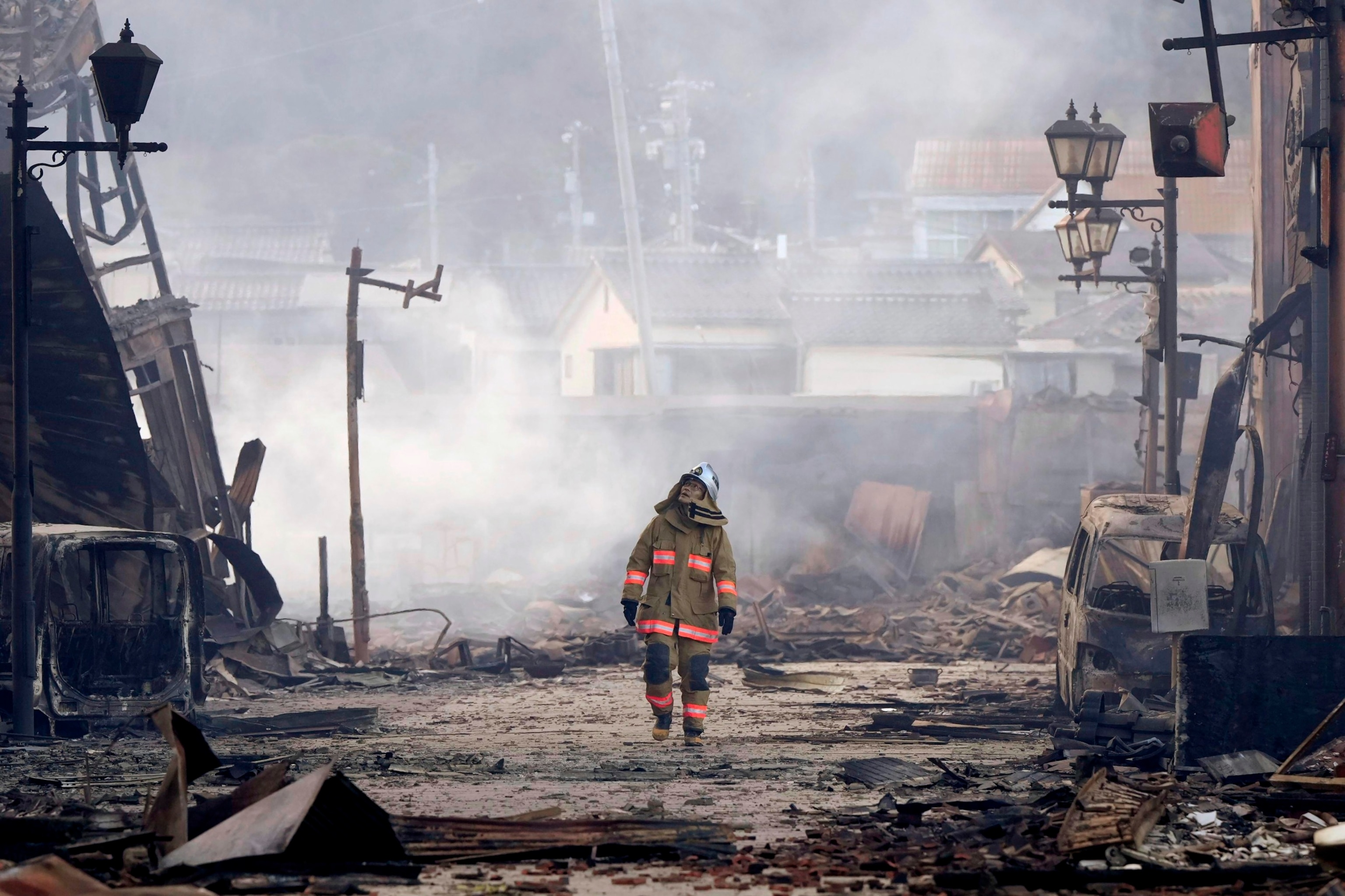 PHOTO: A firefighter looks up the rubble and wreckage of a burnt-out marketplace following earthquake in Wajima, Ishikawa prefecture, Japan, Tuesday, Jan. 2, 2024.