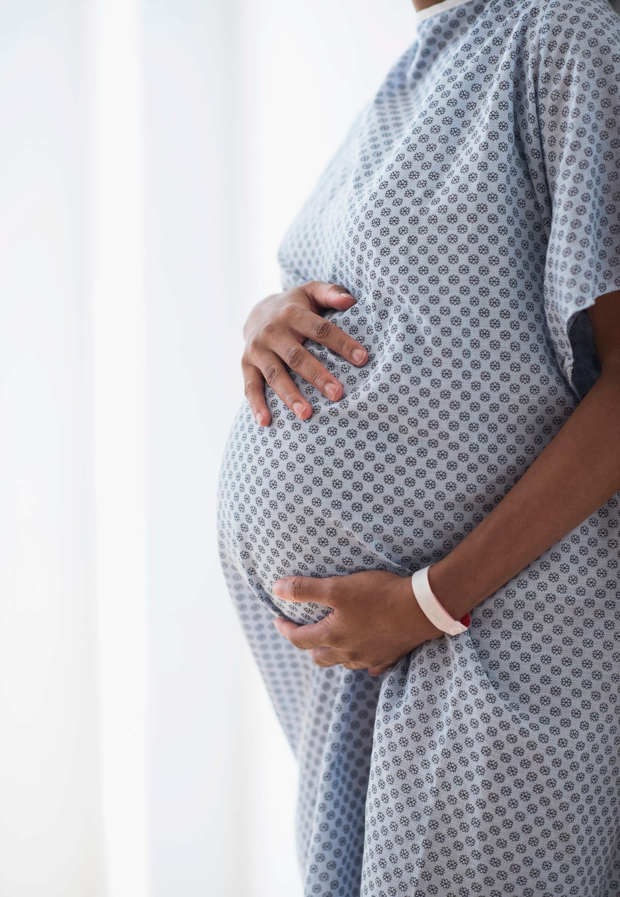 PHOTO: Pregnant African American mother holding her belly in hospital.