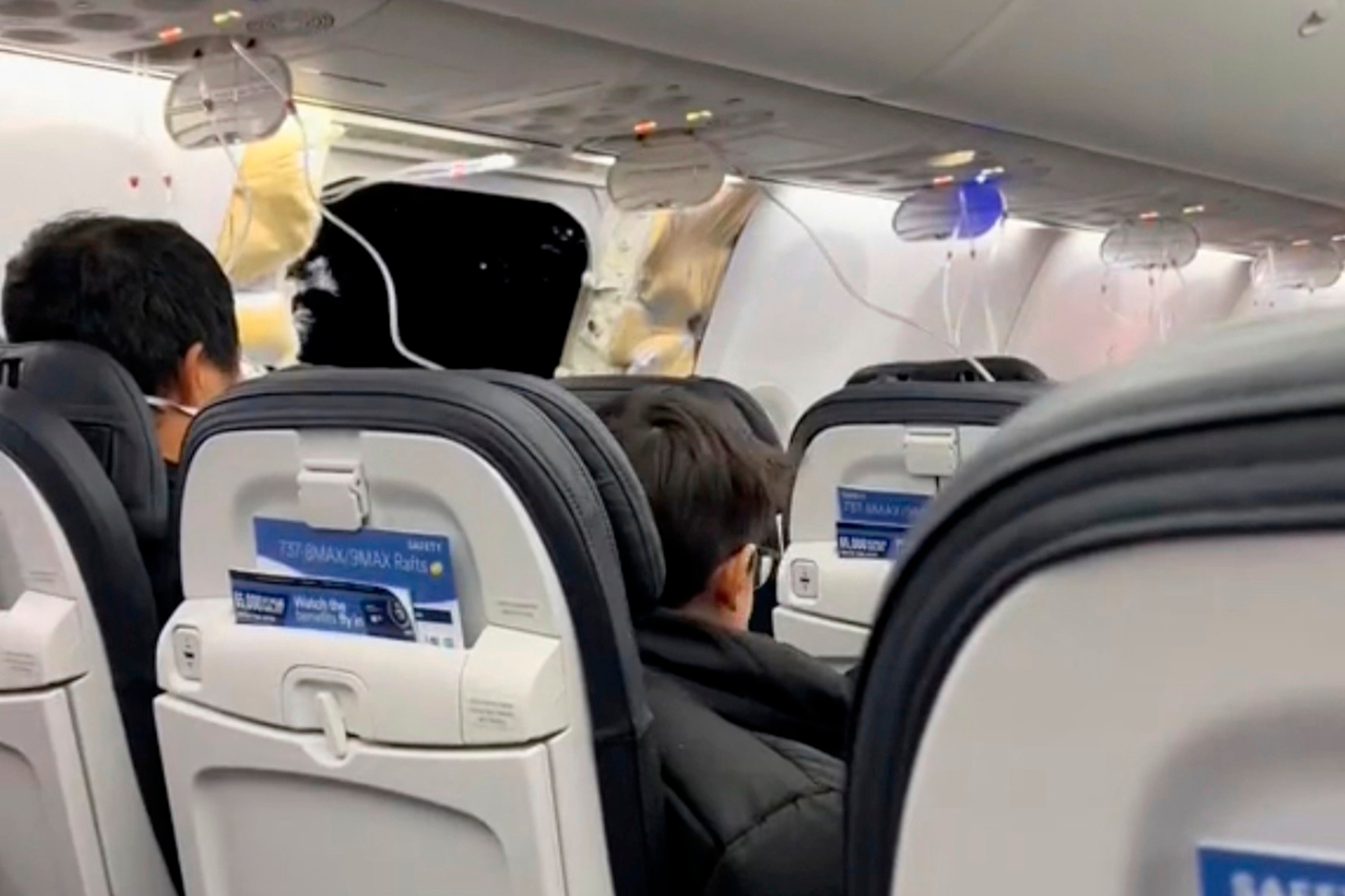 PHOTO: This image from video provided by Elizabeth Le shows passengers near the damage on an Alaska Airlines Boeing 737 Max 9, Flight 1282, which was forced to return to Portland International Airport, on Jan. 5, 2024.