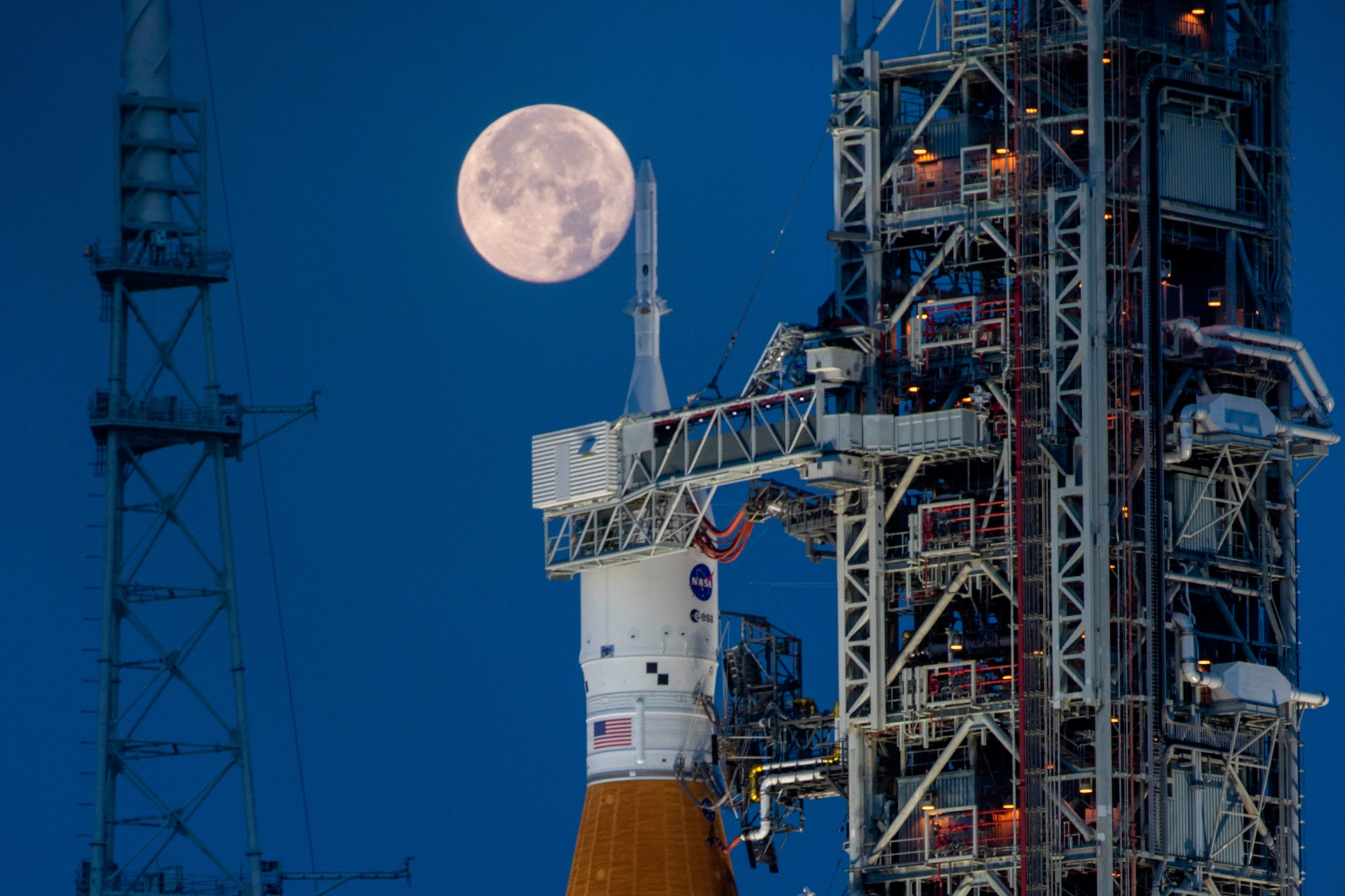 PHOTO: A full moon is seen behind the Artemis I Space Launch System (SLS) and Orion spacecraft at Launch Complex 39B at NASA's Kennedy Space Center in Florida, June 14, 2022. 