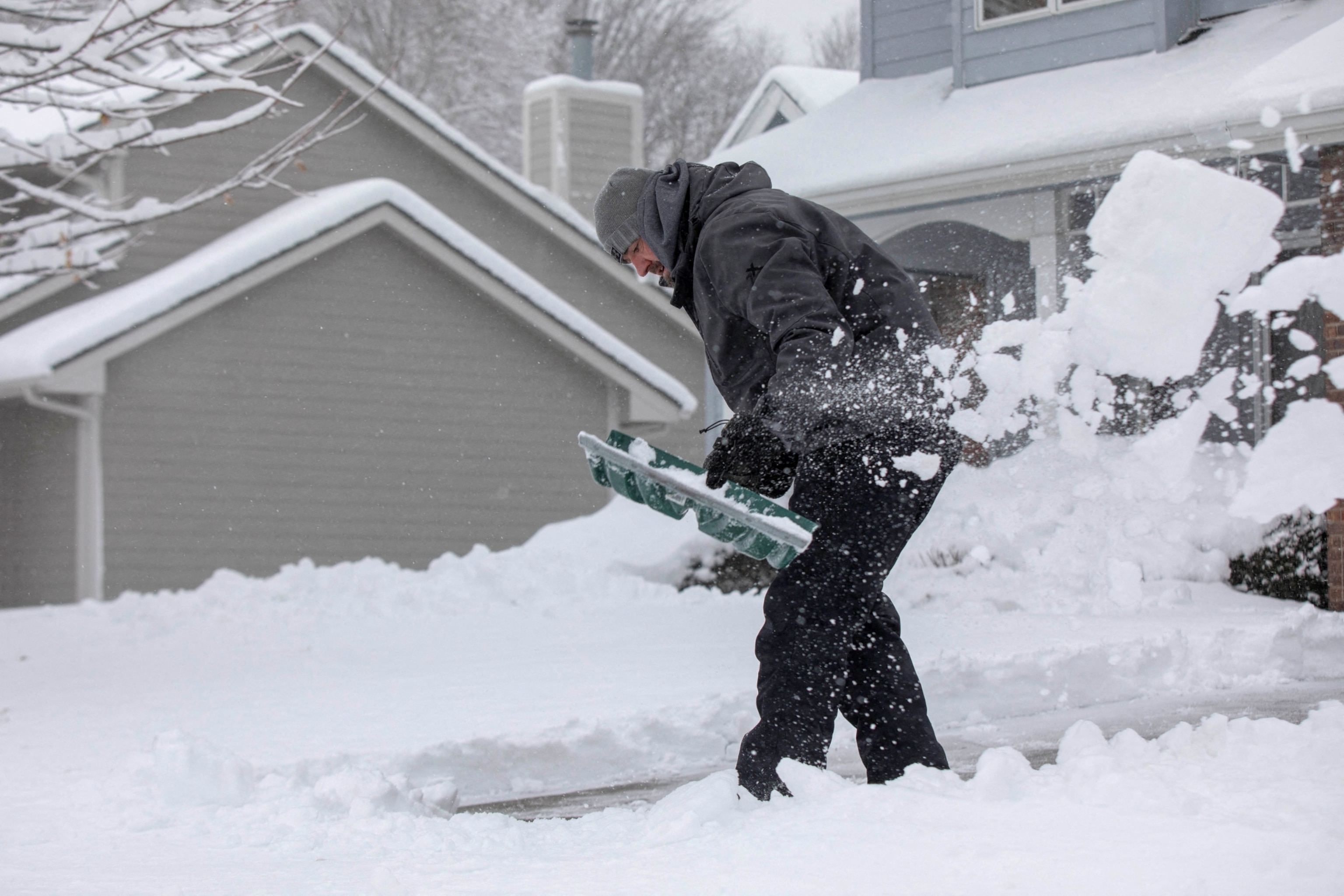 PHOTO: Zach Brobst shovels in his driveway after a snowstorm left several inches of snow in Clive, Iowa, January 9, 2024.