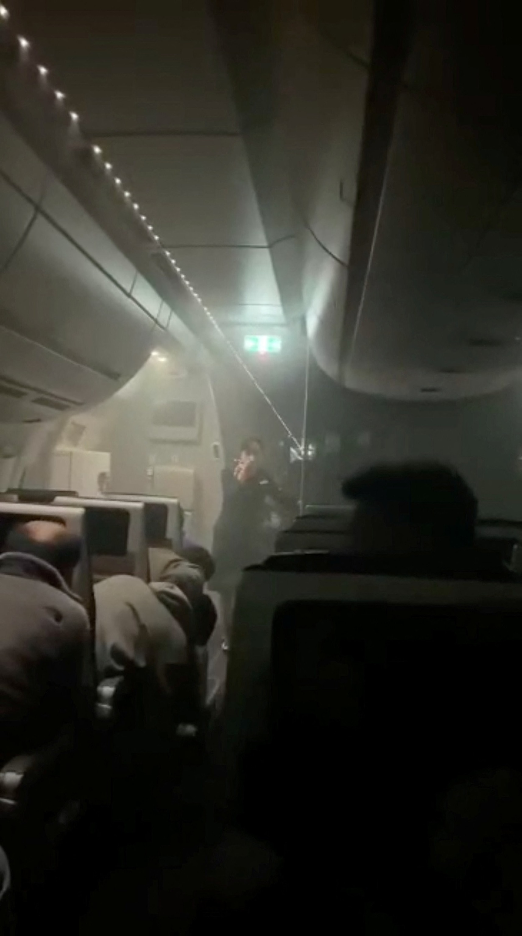 PHOTO: People sit amid smoke inside the Japan Airlines' A350 airplane in this screen grab obtained from social media video.