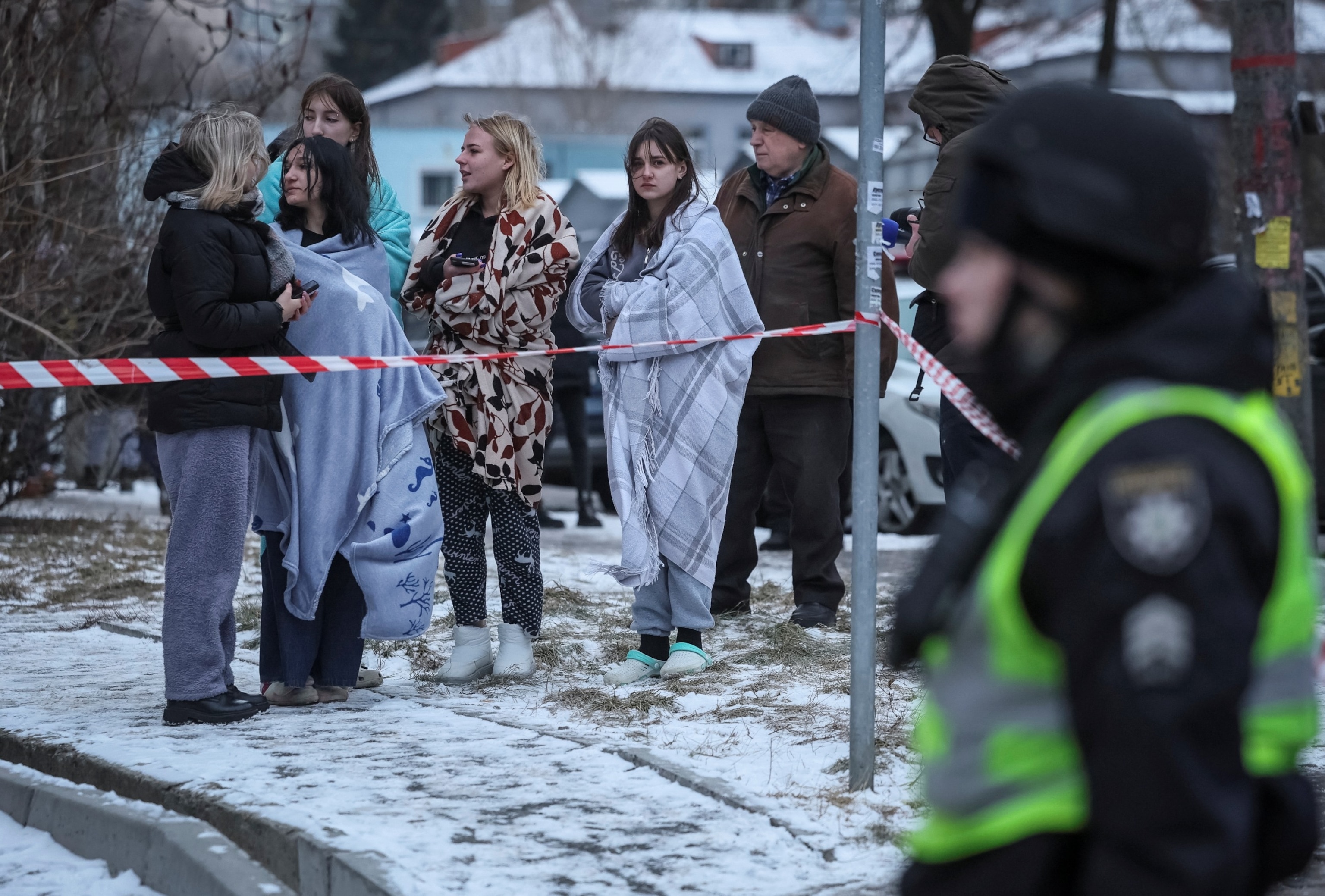 PHOTO: Local residents stand near their apartment building damaged during a Russian missile strike, amid Russia's attack on Ukraine, in Kyiv, Ukraine, Jan. 23, 2024.