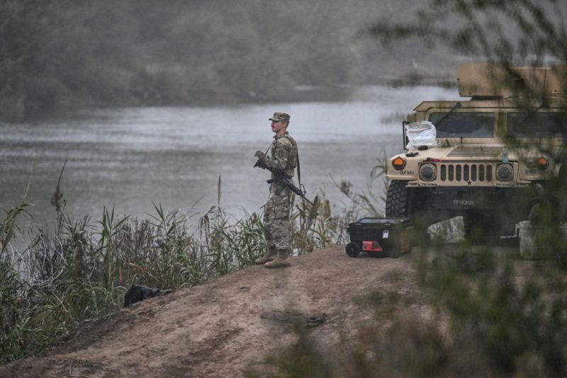 A US National Guard soldier guards the border with Mexico at Eagle Pass, Texas, on December 23, 2023. Faced with the daily arrival of thousands of migrants from Mexico, US states and federal border police are declaring themselves overwhelmed, a crisis that is exposing the administration of US President Joe Biden to heavy fire from its Republican opponents. In recent weeks, the border police have reported some 10,000 people crossing the border every day, an even faster pace than in previous months. (Photo by CHANDAN KHANNA / AFP) (Photo by CHANDAN KHANNA/AFP via Getty Images)