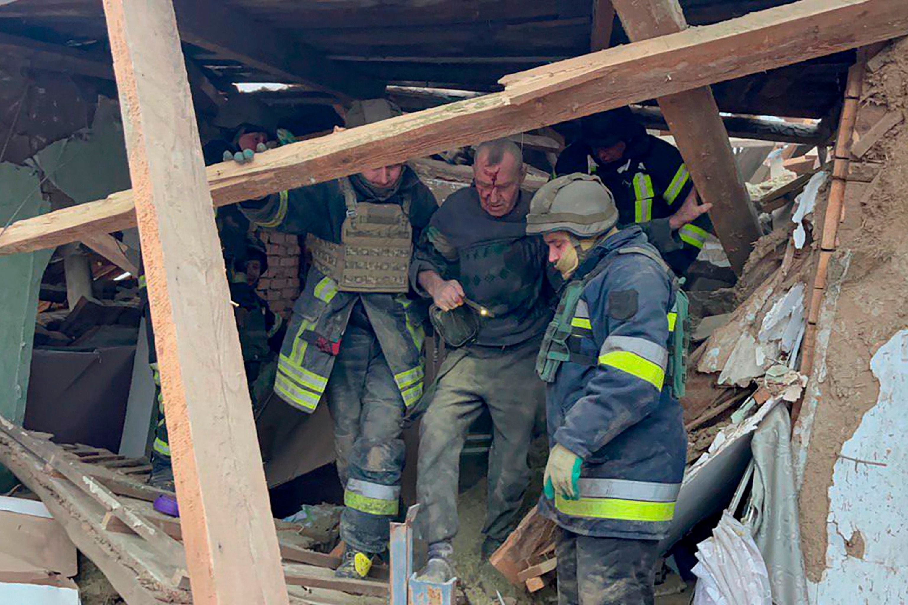 PHOTO: In this photo provided by the Ukrainian Emergency Service, emergency workers help a wounded man after a residential houses were badly damaged in a Russian missile attack, near Kryvyi Rih, Ukraine, Jan. 8, 2024.