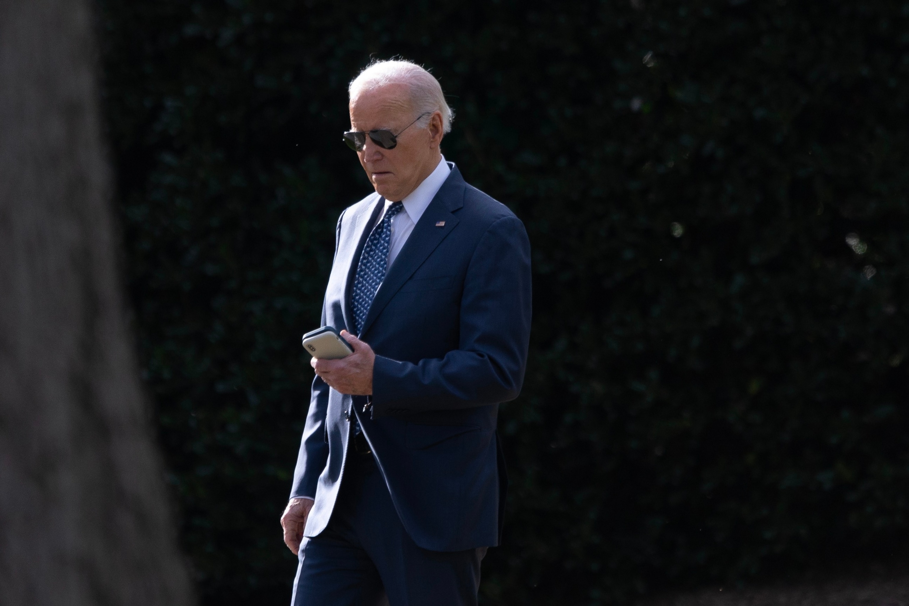 PHOTO: President Joe Biden checks a cell phone while walking to Marine One from the Oval Office at the White House, in Washington, D.C., Feb. 8, 2024. 