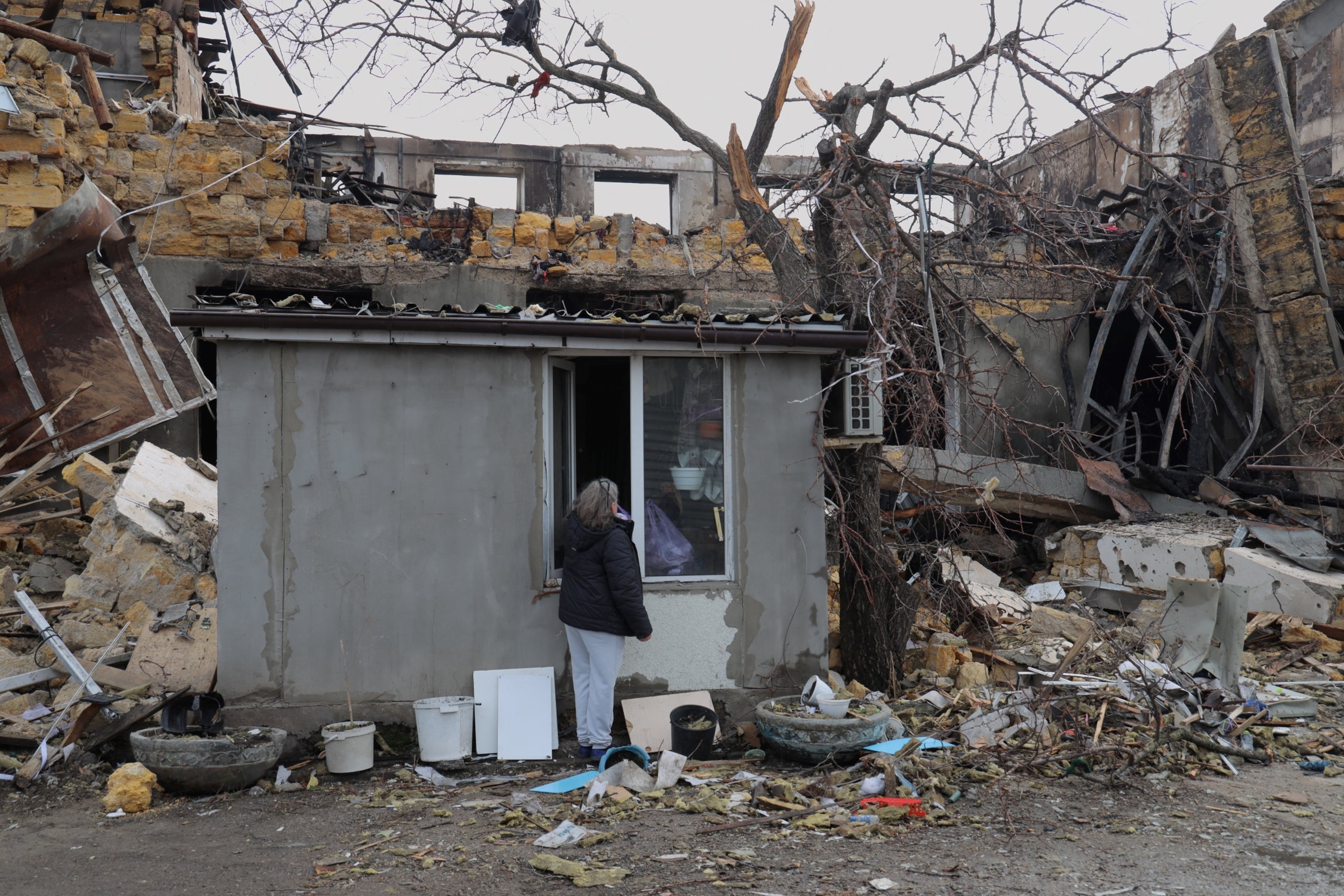 PHOTO: Night watchwoman Olena takes her belongings out of a control point building damaged as a result of a drone attack on a garment factory in Odesa on February 23, 2024, amid the Russian invasion of Ukraine.