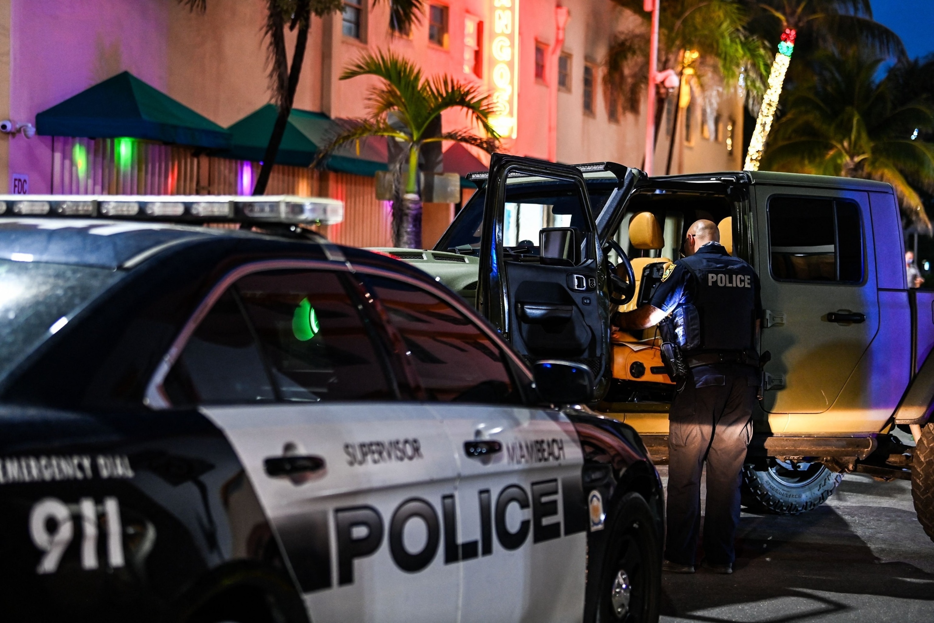 PHOTO: A Miami Beach police officer inspects the inside of a car on Ocean Drive in Miami Beach, on March 22, 2021.