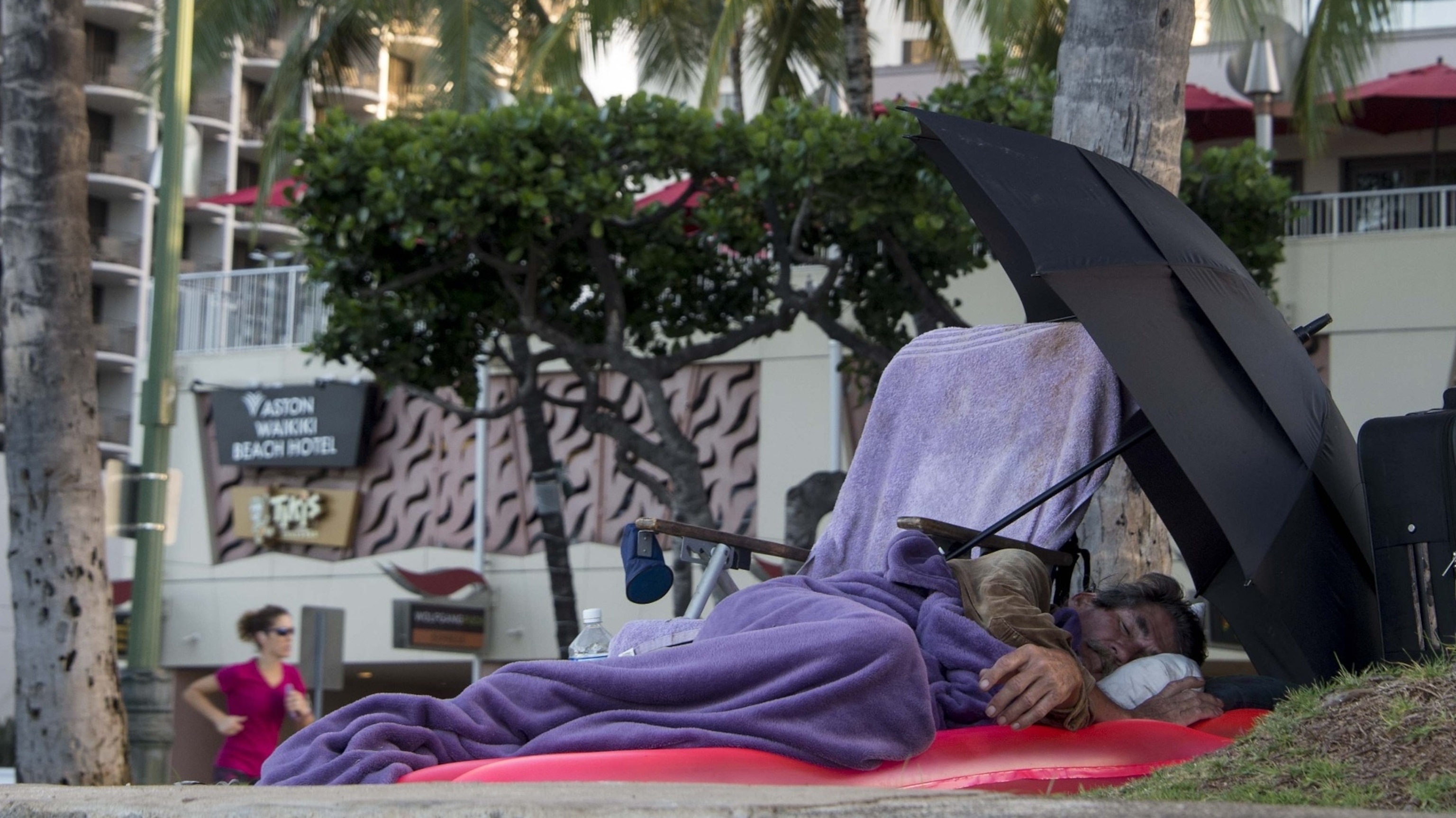 PHOTO: In this Dec. 20, 2014 file photo, a homeless man sleeps by Waikiki beach in Honolulu.