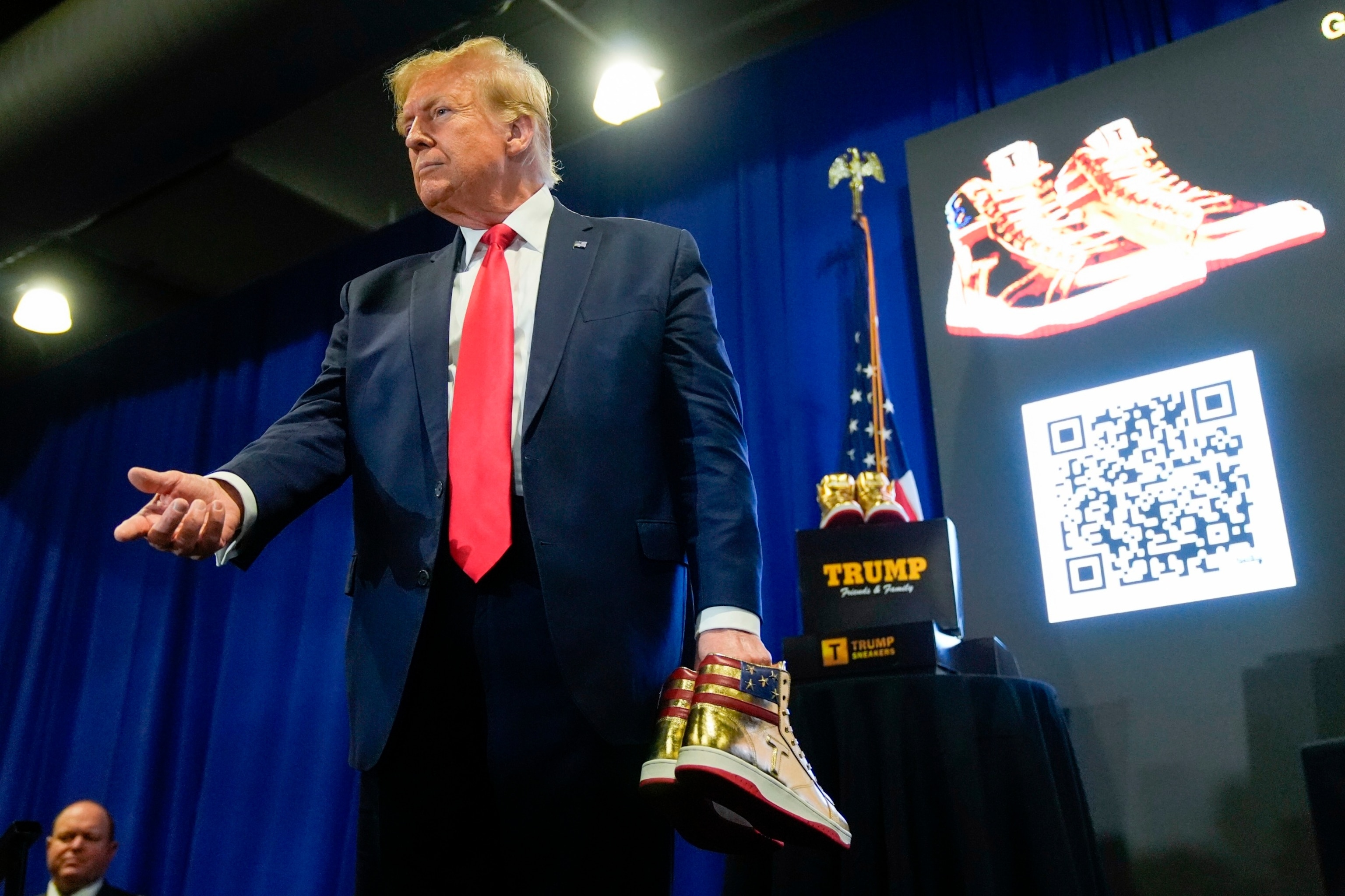 PHOTO: Former President Donald Trump holds gold Trump sneakers at Sneaker Con Philadelphia in Philadelphia, PA, Feb. 17, 2024.