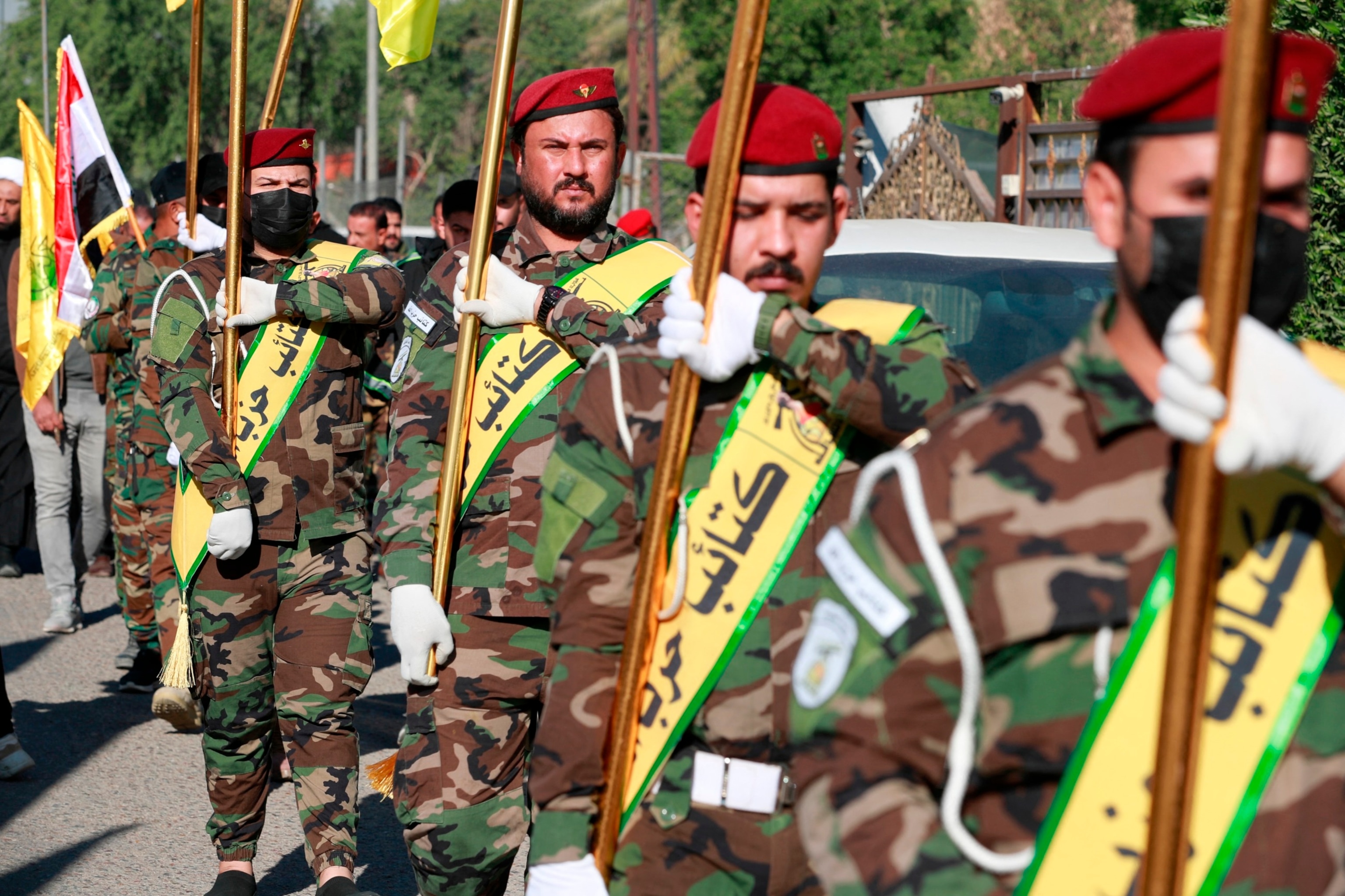 PHOTO: Fighters lift flags of Iraq and paramilitary groups, including al-Nujaba and Kataib Hezbollah, during a funeral in Baghdad for five militants killed a day earlier in a US strike in northern Iraq, Dec. 4, 2023. 