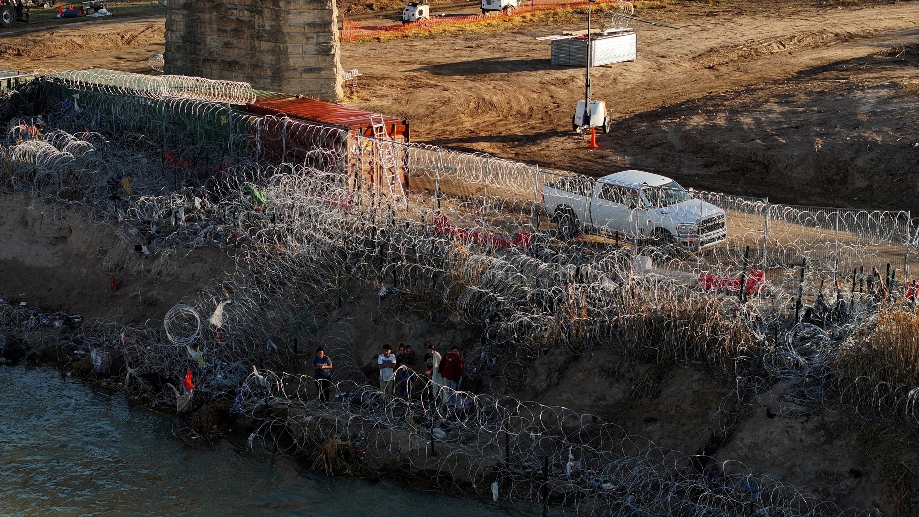 PHOTO: A group of migrants stand on the edge of Rio Grande in Eagle Pass, Texas, Feb. 3, 2024. 