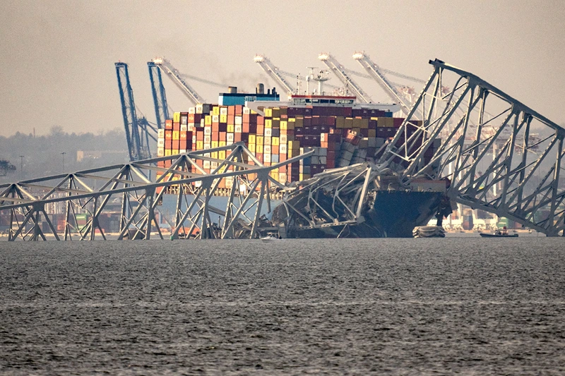 US-TRANSPORT-ACCIDENT-ECONOMY
Part of the steel frame of the Francis Scott Key Bridge sits on top of the container ship Dali after the bridge collapsed in Baltimore, Maryland, on March 26, 2024. The bridge collapsed early March 26 after being struck by the Singapore-flagged Dali container ship, sending multiple vehicles and people plunging into the frigid harbor below. There was no immediate confirmation of the cause of the disaster, but Baltimore's Police Commissioner Richard Worley said there was "no indication" of terrorism. (Photo by Kent Nishimura / AFP) (Photo by KENT NISHIMURA/AFP via Getty Images)