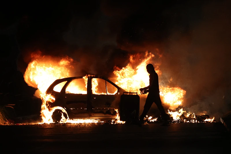 TOPSHOT-FRANCE-OVERSEAS-CRIME-POLICE-DEMO
TOPSHOT - A protester walks by a burning car during clashes with police in Le Port, French Indian Ocean island of La Reunion, on June 30, 2023, three days after a 17-year-old boy was shot in the chest by police at point-blank range in Nanterre, a western suburb of Paris. A third consecutive night of violence in France sparked by the killing of a teenager by a policeman during a traffic stop has left 249 police and gendarmes injured, the interior ministry announced on June 30, 2023. (Photo by Richard BOUHET / AFP) (Photo by RICHARD BOUHET/AFP via Getty Images)