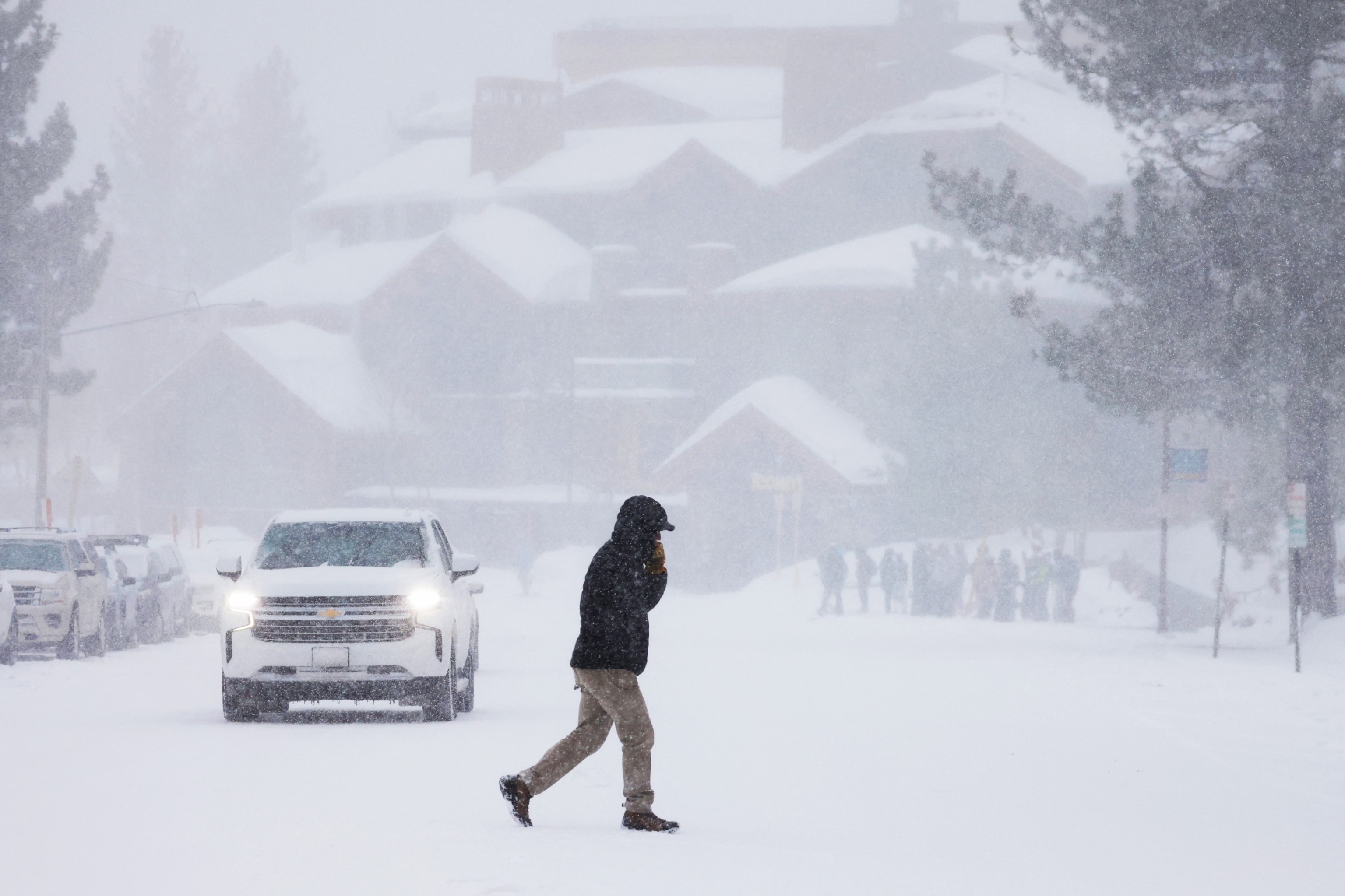 PHOTO: A person crosses a snow-covered road in Mammoth Lakes, Calif., on March 1, 2024. 