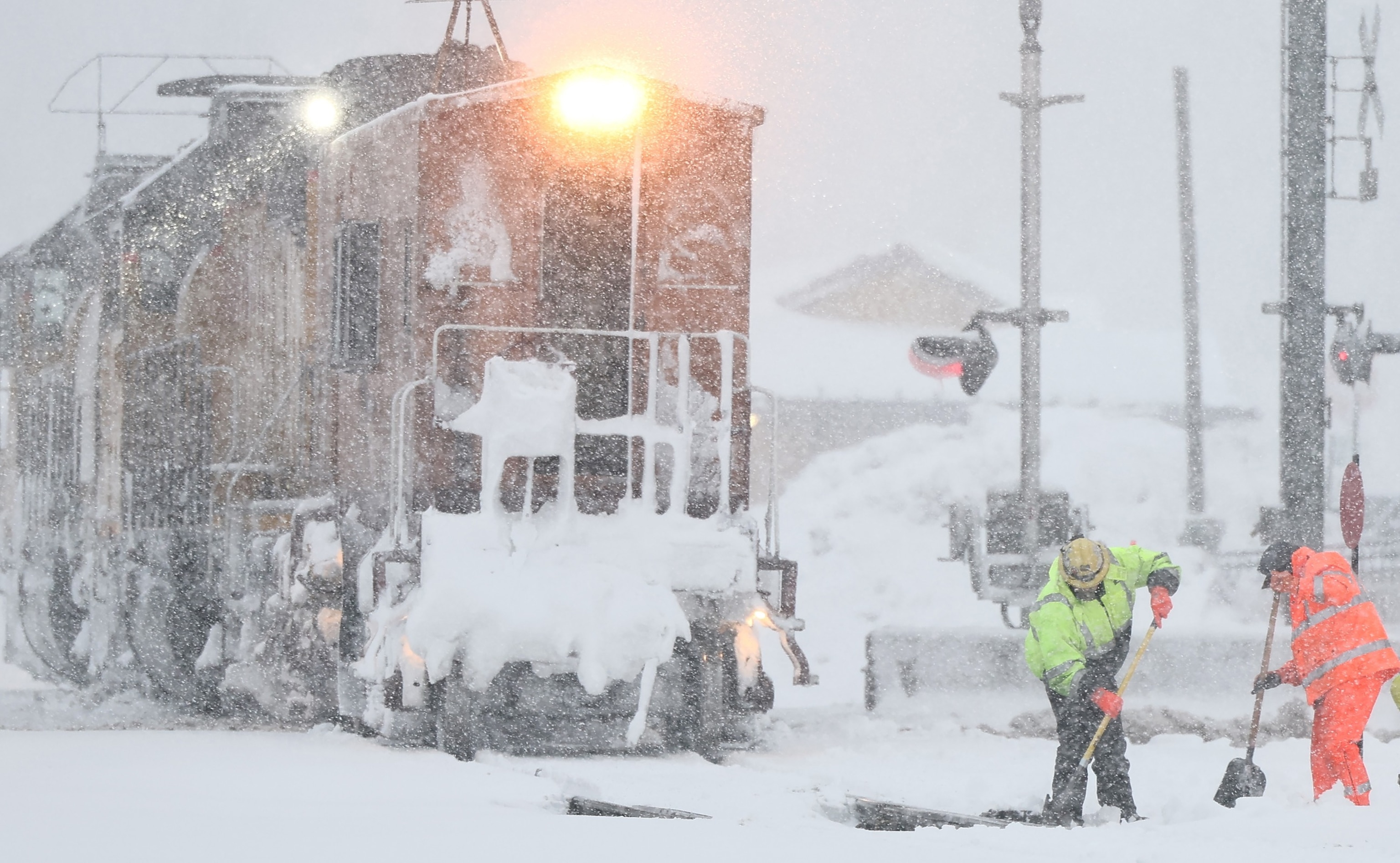 PHOTO: Workers clear train tracks as snow falls north of Lake Tahoe in the Sierra Nevada mountains during a powerful winter storm on March 01, 2024 in Truckee, Calif.