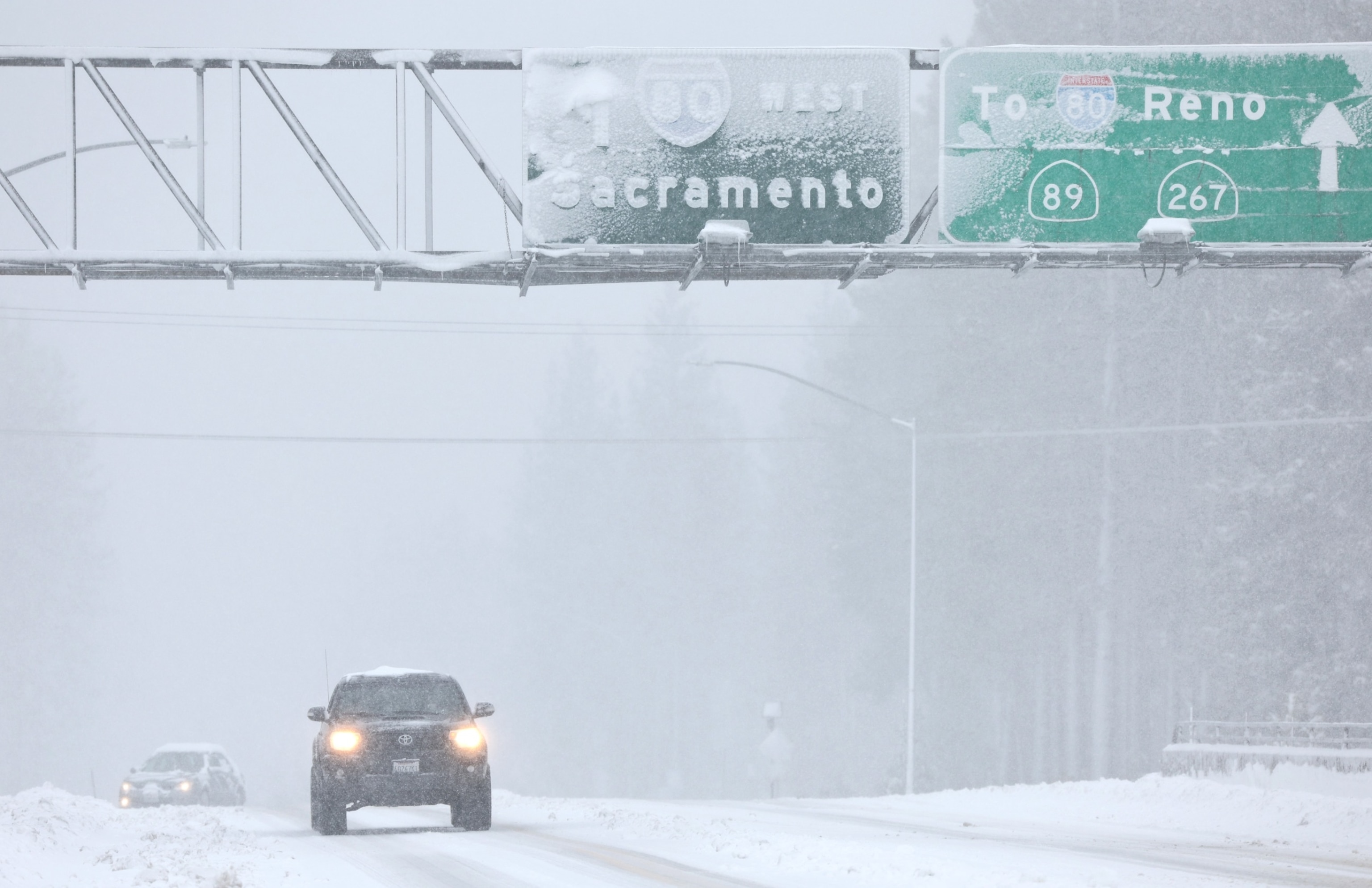 PHOTO: Vehicles drive as snow falls north of Lake Tahoe in the Sierra Nevada mountains during a powerful winter storm on March 01, 2024 in Truckee, Calif.