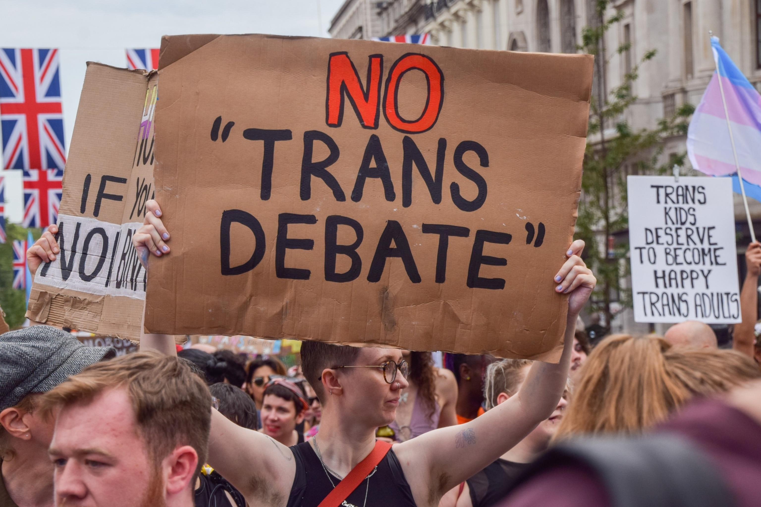 PHOTO: A protester holds a 'No trans debate' placard during the demonstration in Piccadilly Circus. Thousands of people marched through central London during Trans Pride 2023.