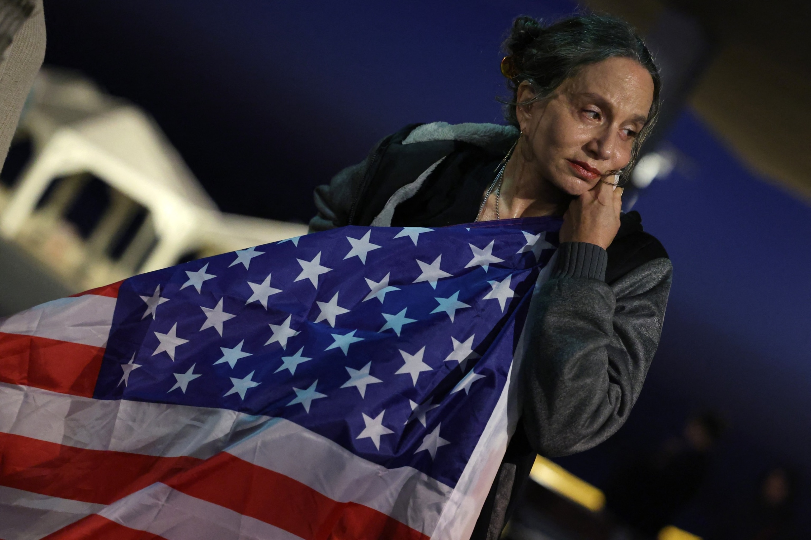 PHOTO: A woman leans on the US flag during a gathering called for by relatives of Israeli hostages held in Gaza, in front of the branch office of the U.S. embassy in the coastal city of Tel Aviv, Mar. 5, 2024.