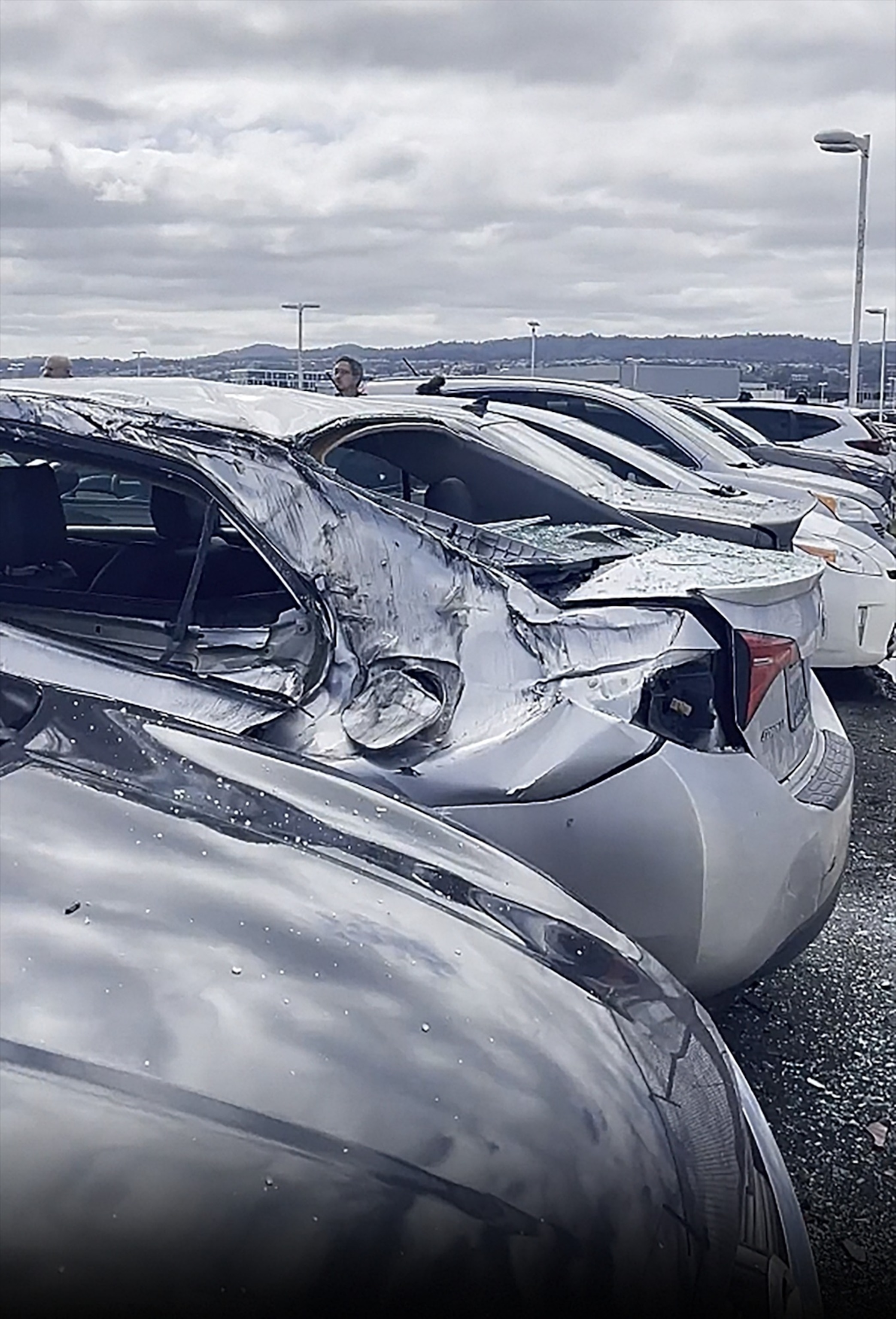 PHOTO: Damaged cars are seen in a parking lot after a United Airlines airplane lost a landing gear tire while taking off from San Francisco Airport, Mar. 7, 2024.