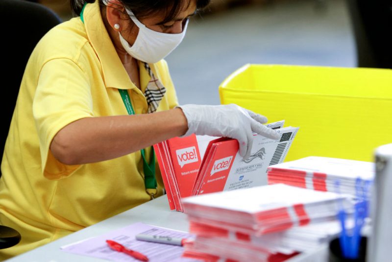 An election worker opens envelopes containing vote-by-mail ballots for the August 4 Washington state primary at King County Elections in Renton, Washington on August 3, 2020.A sign explaining signature verification is pictured as vote-by-mail ballots for the August 4 Washington state primary are processed at King County Elections in Renton, Washington on August 3, 2020. (Photo by Jason Redmond / AFP) (Photo by JASON REDMOND/AFP via Getty Images)