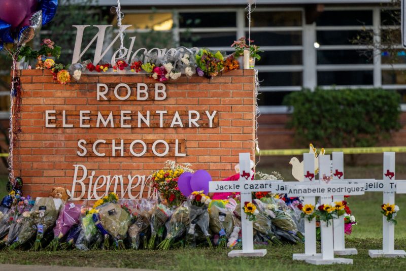 UVALDE, TEXAS - MAY 26: A memorial is seen surrounding the Robb Elementary School sign following the mass shooting at Robb Elementary School on May 26, 2022 in Uvalde, Texas. According to reports, 19 students and 2 adults were killed, with the gunman fatally shot by law enforcement. (Photo by Brandon Bell/Getty Images)