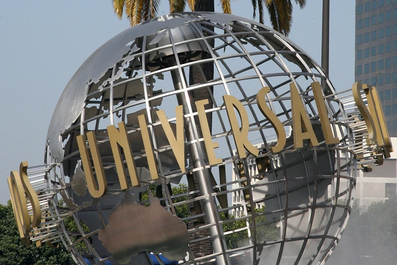 The entrance of Universal Studios in Ho...
Hollywood, UNITED STATES: The entrance of Universal Studios in Hollywood is pictured 09 April 2007. Universal Studios Hollywood is the original Universal Studios theme park, created initially to offer tours of the real Universal Studios soundstages and sets. It is one of four fully-fledged Universal Studios Theme Parks, along with Universal Studios Orlando, Universal Studios Japan, and the upcoming Universal Studios Singapore, which will be completed by 2010. From the beginning, Universal has offered tours of its studio. In the silent-film days, Carl Laemmle's tour included a chance to buy fresh produce, since then-rural Universal City was still in part a working farm. Shortly after MCA took over Universal Pictures in 1962, accountants suggested a tour stop in the studio commissary would increase profits, and in 1964, the modest tour was expanded to include a series of dressing room walk-throughs, peeks at actual production, and later, staged events. This grew over the years into a full-blown theme park - the narrated tram (formerly "Glamortram") tour still runs through the studio's active backlot, but the staged events, stunt demonstrations and high-tech rides overshadow the motion-picture production that once lured fans in Universal Studios Hollywood. AFP PHOTO/GABRIEL BOUYS (Photo credit should read GABRIEL BOUYS/AFP via Getty Images)