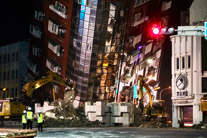 TAIWAN-EARTHQUAKE
Emergency personnel stand in front of a partially collapsed building leaning over a street in Hualien on April 3, 2024, after a major earthquake hit Taiwan's east. At least nine people were killed and more than 1,000 injured on April 3 by a powerful earthquake in Taiwan that damaged dozens of buildings and prompted tsunami warnings that extended to Japan and the Philippines before being lifted. (Photo by Sam Yeh / AFP) (Photo by SAM YEH/AFP via Getty Images)