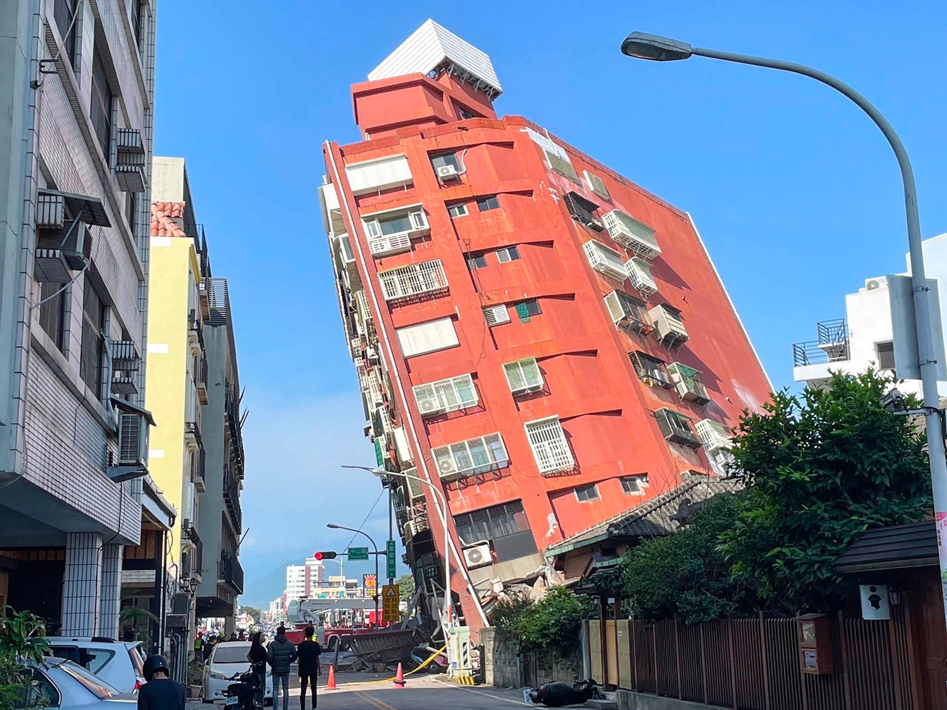 PHOTO: This photo taken by Taiwan's Central News Agency on April 3, 2024 shows people looking at a damaged building in Hualien, after a major earthquake hit Taiwan's east. 