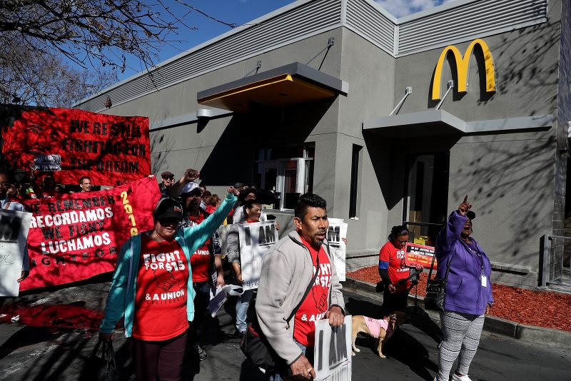 OAKLAND, CA - FEBRUARY 12: Fast food workers and union members carry signs as they stage a protest outside of a McDonald's restaurant on February 12, 2018 in Oakland, California. Dozens of fast food workers staged a protest outside of a McDonald's restaurant to demand a $15 an hour minimum wage on the 50th anniversary of the historic Memphis Sanitation Strike that was led by Dr. Martin Luther King Jr. (Photo by Justin Sullivan/Getty Images)