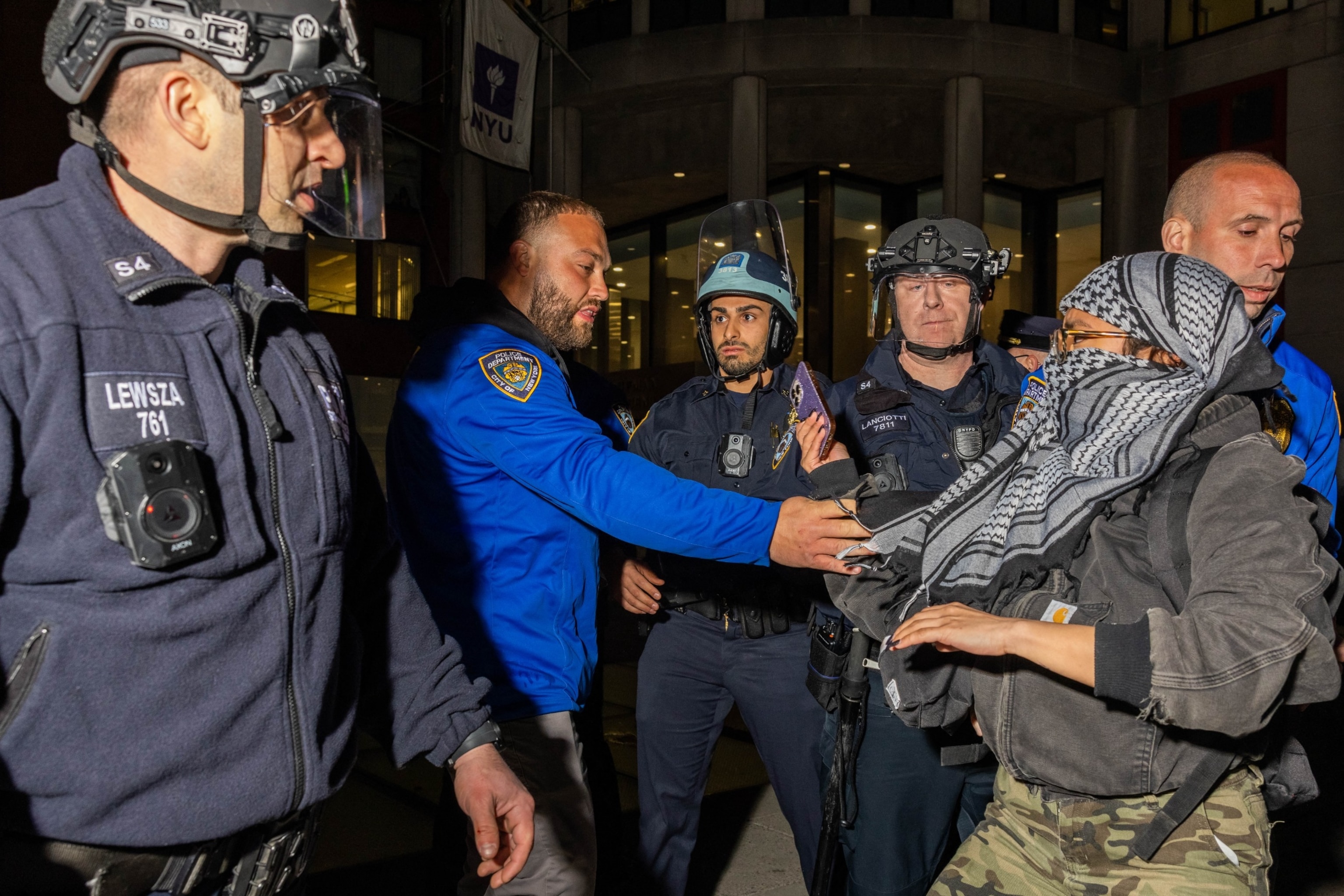 PHOTO: NYPD officers detain pro-Palestinian students and protesters who had set up an encampment on the campus of New York University to protest the Israel-Hamas war, in New York on April 22, 2024. 