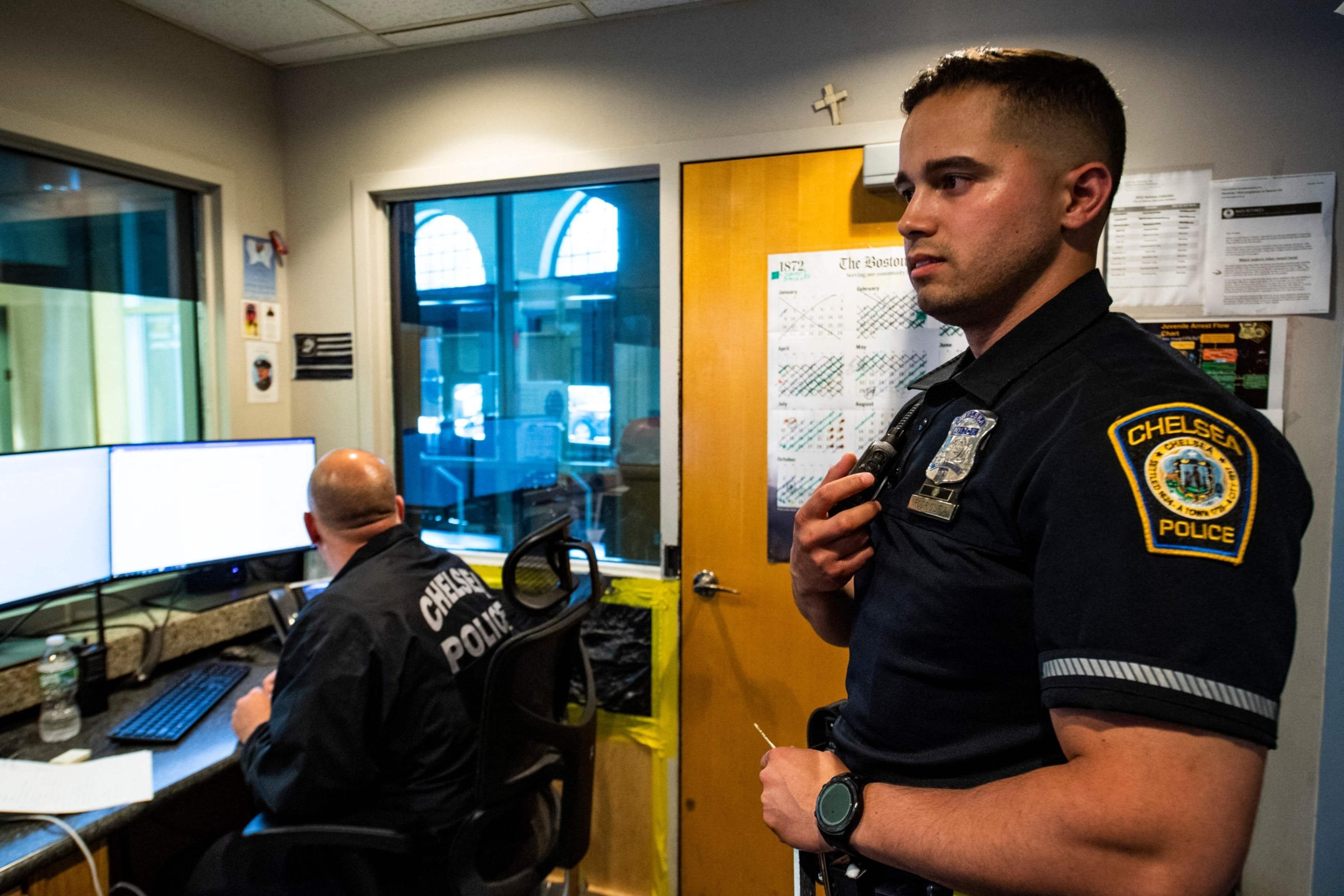PHOTO: Officer Jose Rodriguez, 32 (R), responds to a call on his radio while inside the dispatch room at the police station in Chelsea, Mass., May 13, 2022.