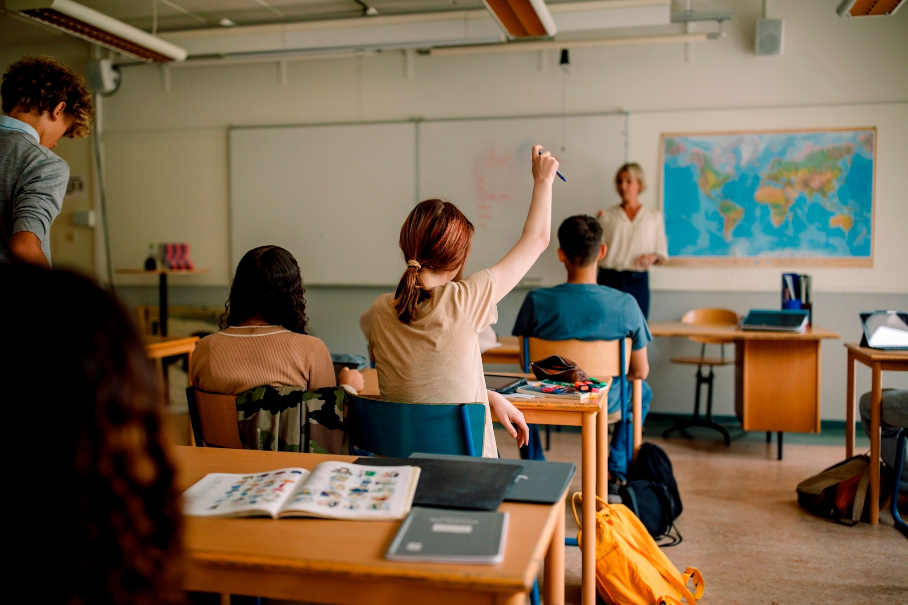 PHOTO: In this undated stock photo, a student raises her hand in class.