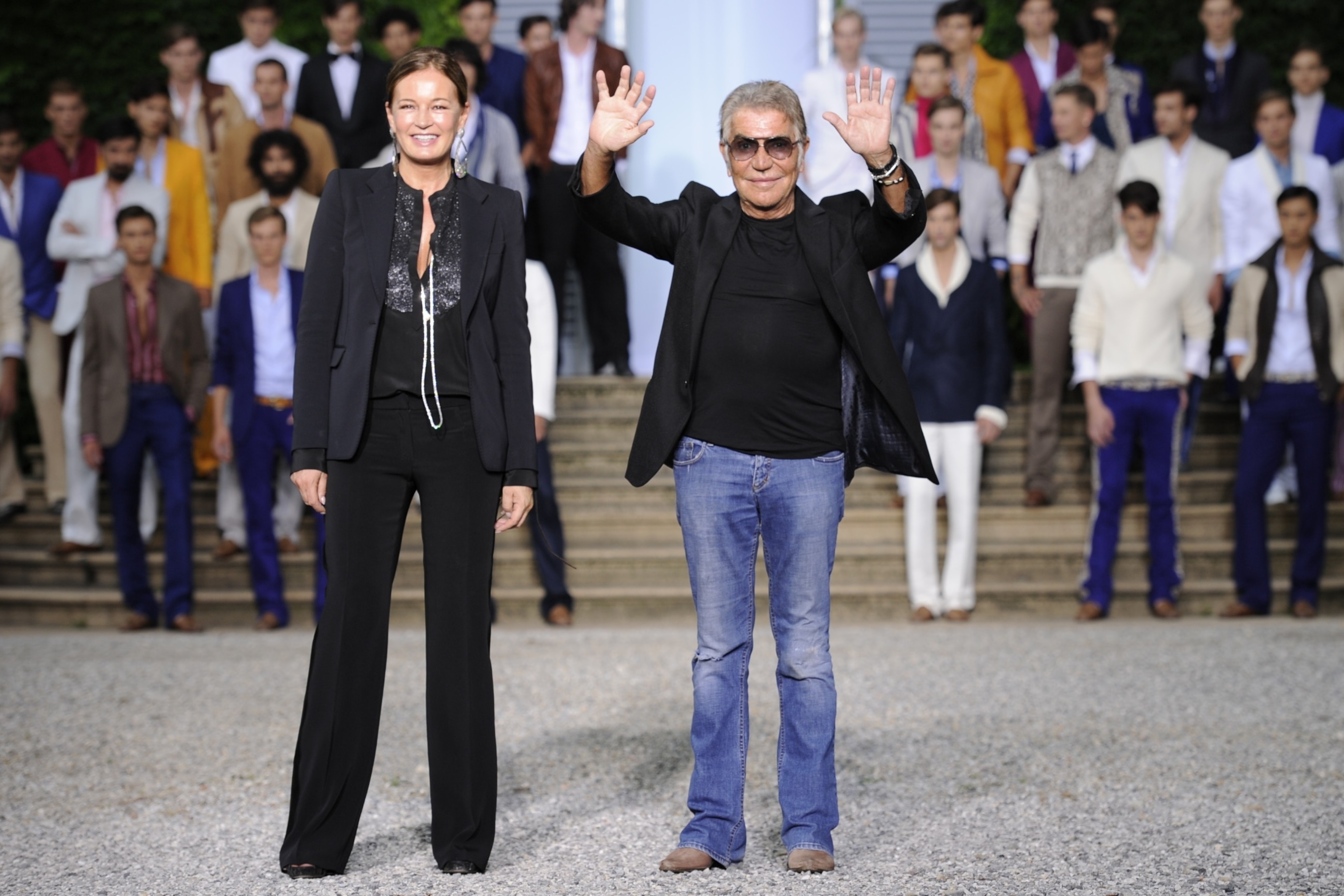 PHOTO: Fashion designer Roberto Cavalli and his wife Eva acknowledge the audience after the Roberto Cavalli Spring-Summer 2012 Menswear collection, June 18, 2011, during the Men's fashion week in Milan. 