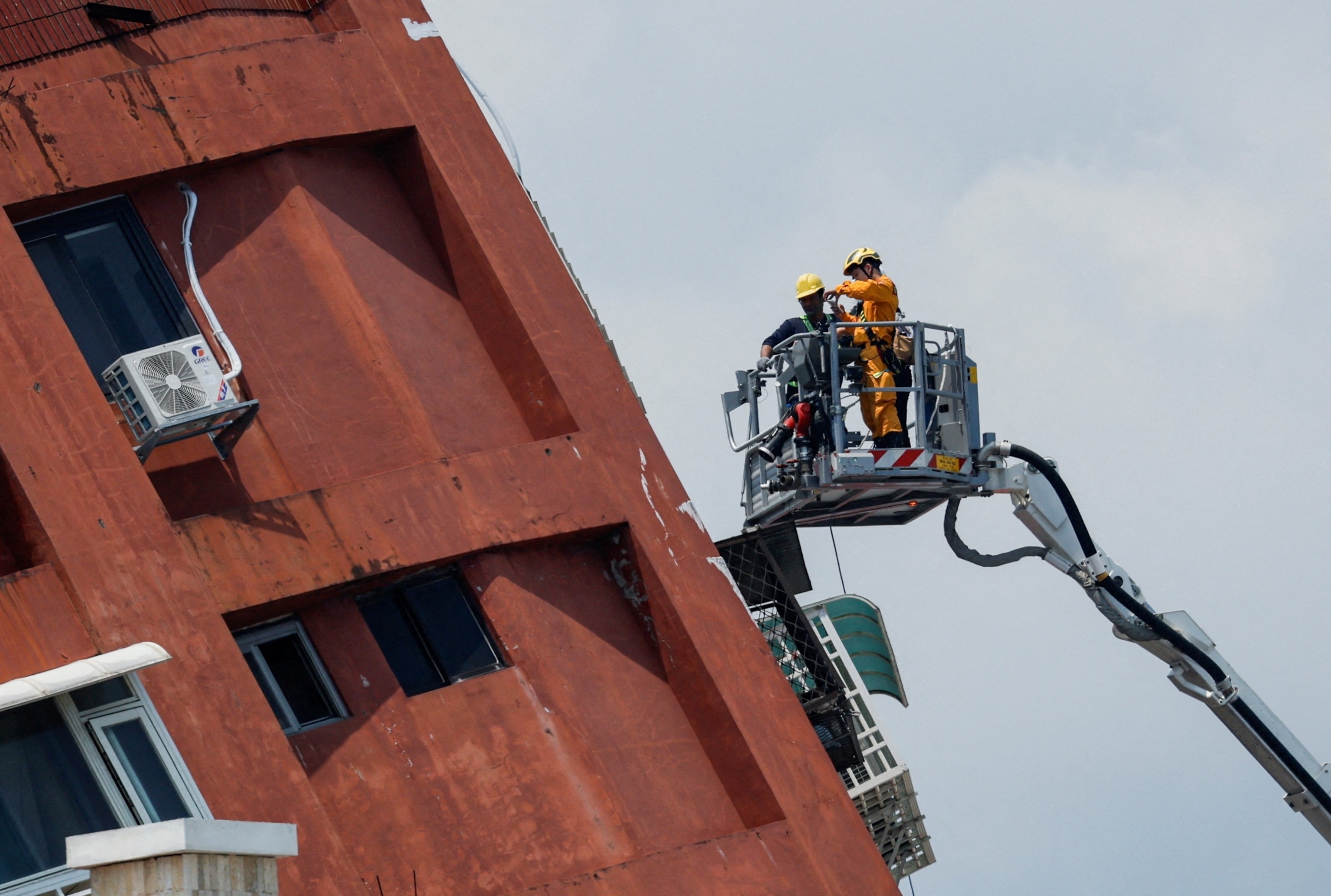 PHOTO: Workers carry out operations while on the elevated platform of a firefighting truck at the site where a building collapsed, following the earthquake, in Hualien, Taiwan, April 4, 2024.