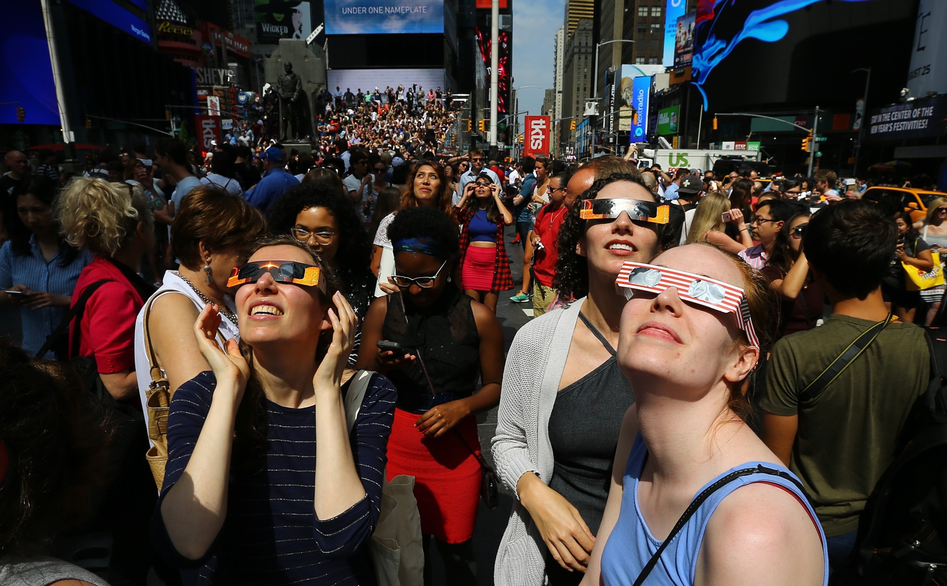 PHOTO: People gather to observe the total solar eclipse with solar eclipse glasses at the Times Square in New York City, Aug. 21, 2017. 