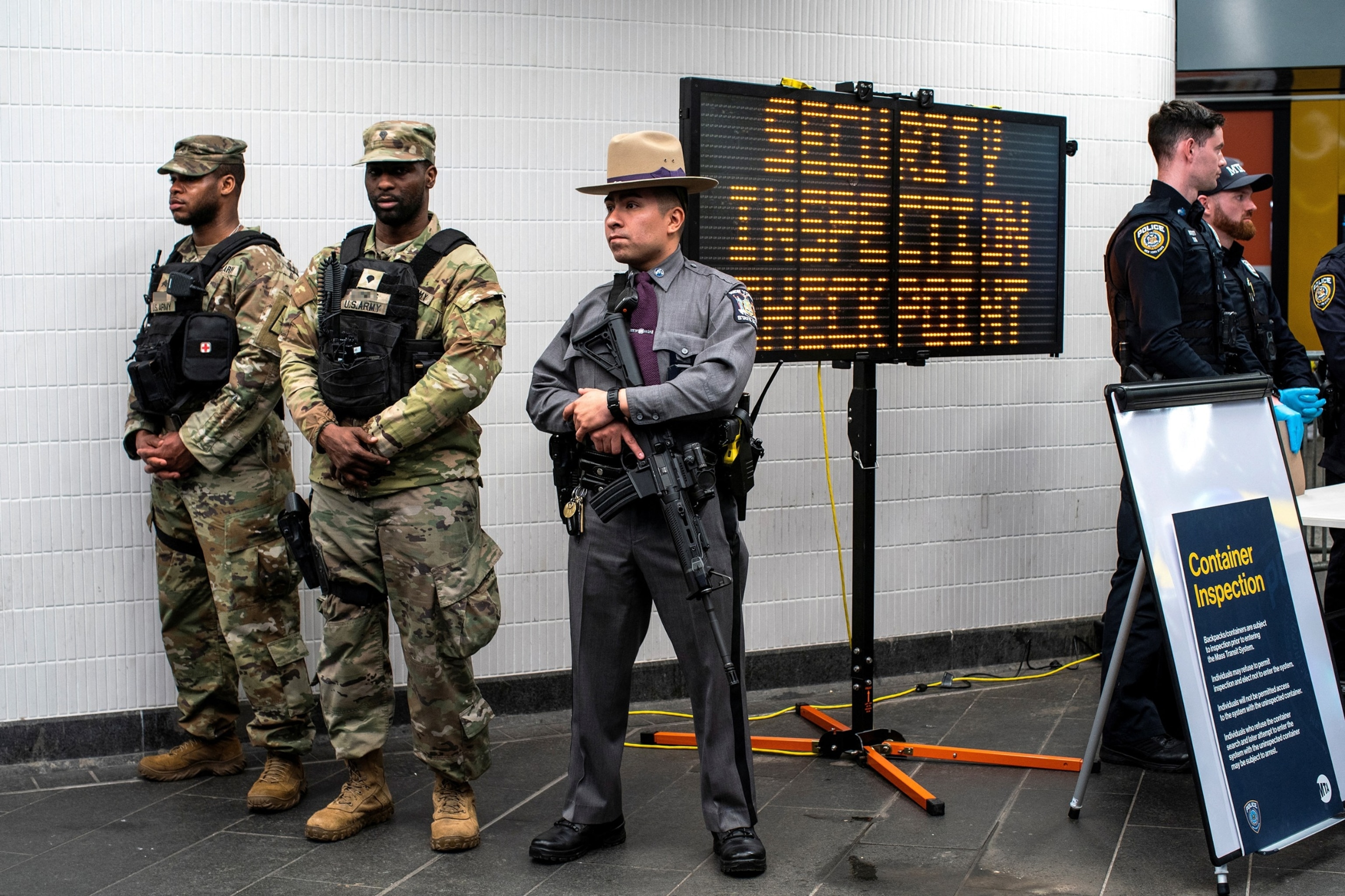 PHOTO: New York State Police officer, members of the New York State National Guard and NYPD officers stand guard in a check point to check bags inside the entrance of subway station in New York, on March 7, 2024.