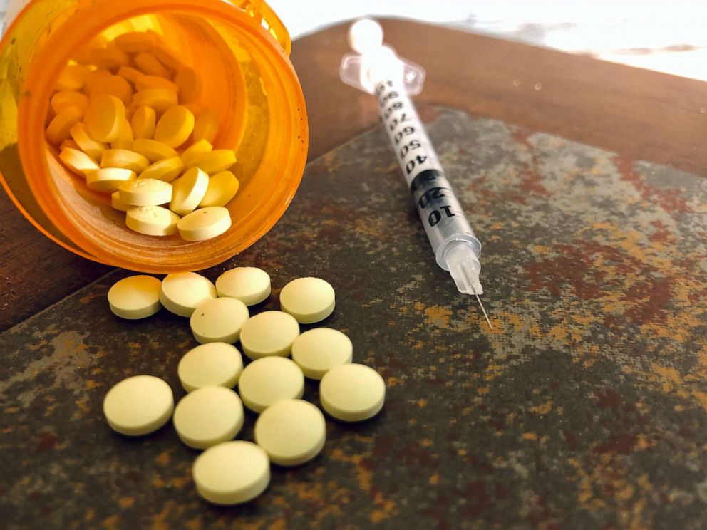 PHOTO: Opioid pills sit next to a syringe in an undated stock image.