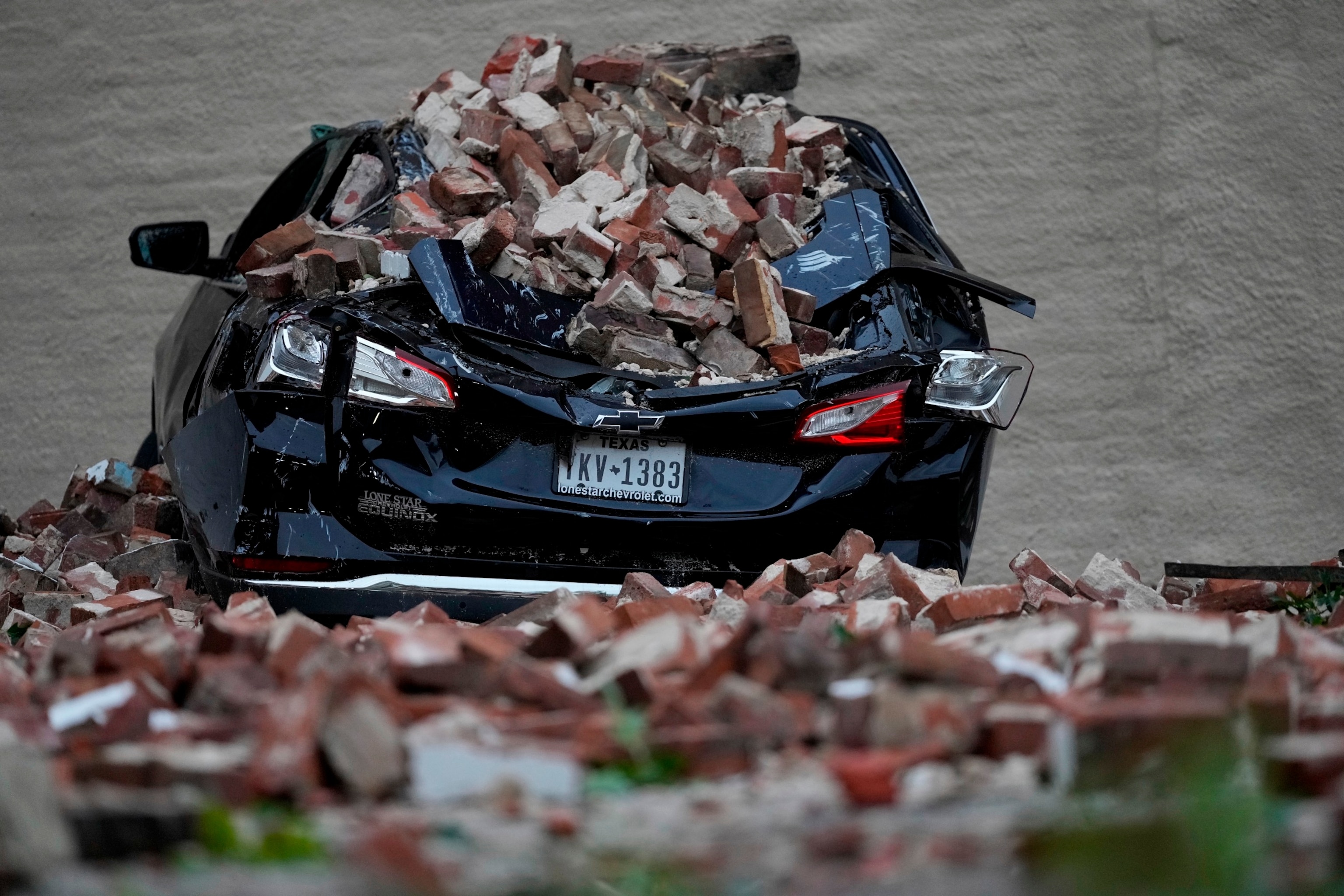 PHOTO: A car sits under fallen bricks in the aftermath of a severe thunderstorm May 17, 2024, in Houston. 