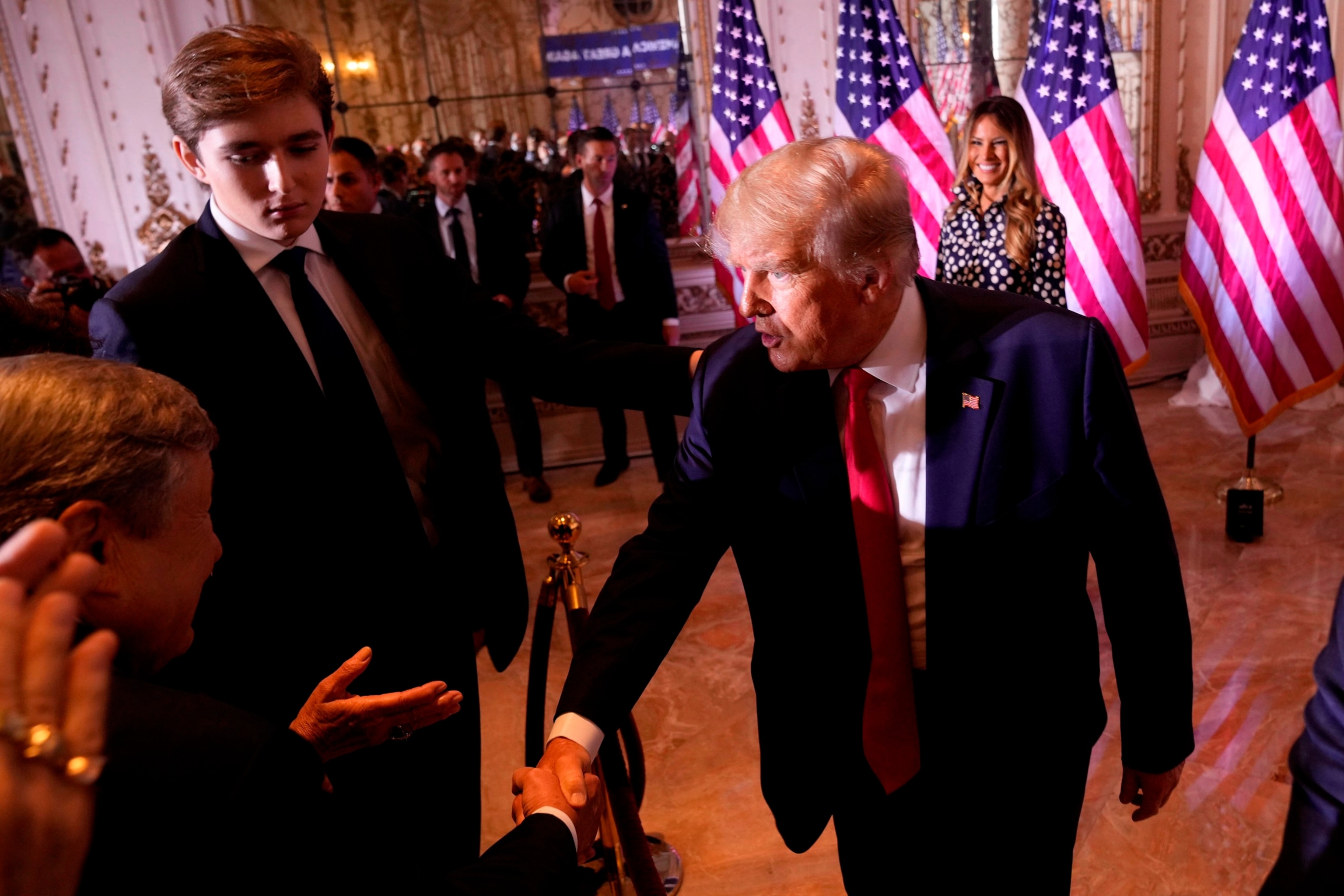 PHOTO: In this Nov. 15, 2022, file photo, former President Donald Trump greets people after announcing he is running for president for the third time as he speaks at Mar-a-Lago, in Palm Beach, Fla. Son Barron Trump watches. 