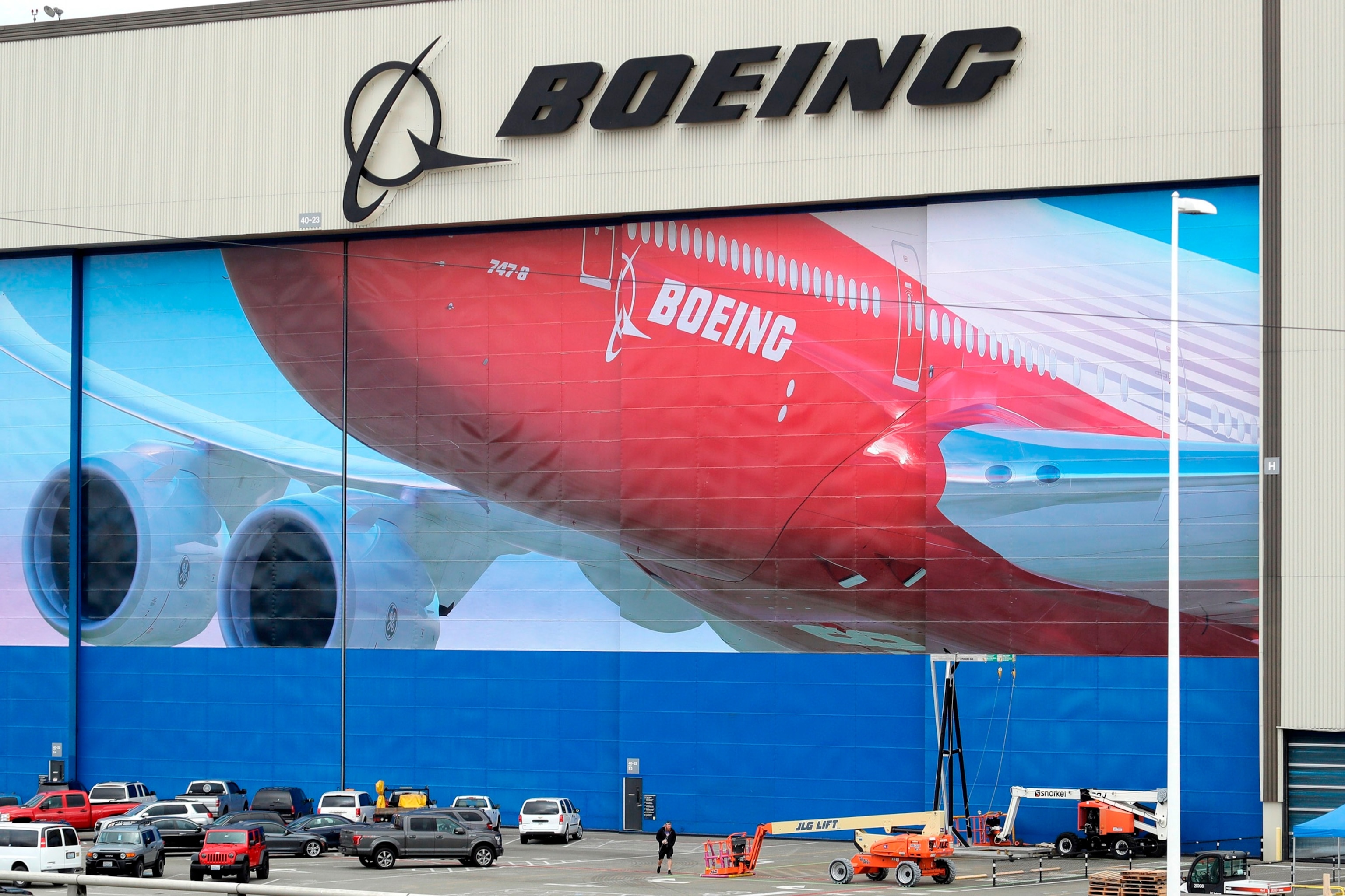 PHOTO: In this March 23, 2020, file photo, a worker walks near a mural of a Boeing 747-8 airplane at the company's manufacturing facility in Everett, Wash.